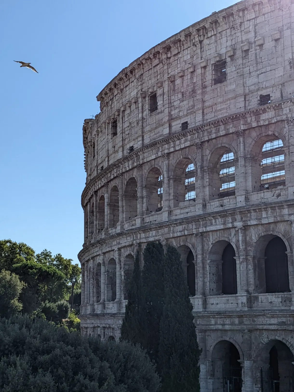 Façade extérieure aux trois étages d'arcades sous le ciel bleu