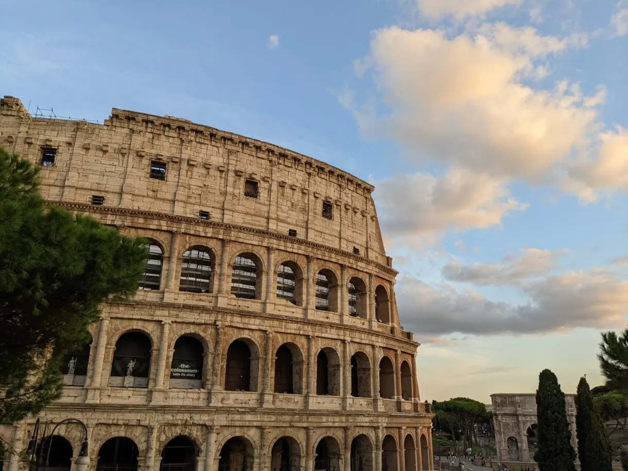 Arcades du Colisée sous un ciel rose de fin de journée