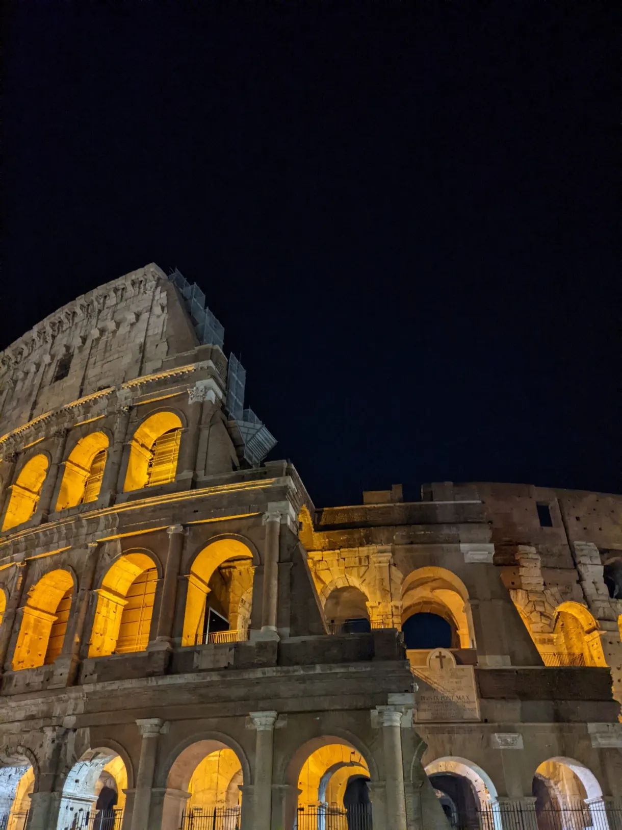 Arcades illuminées d'orange dans la nuit romaine