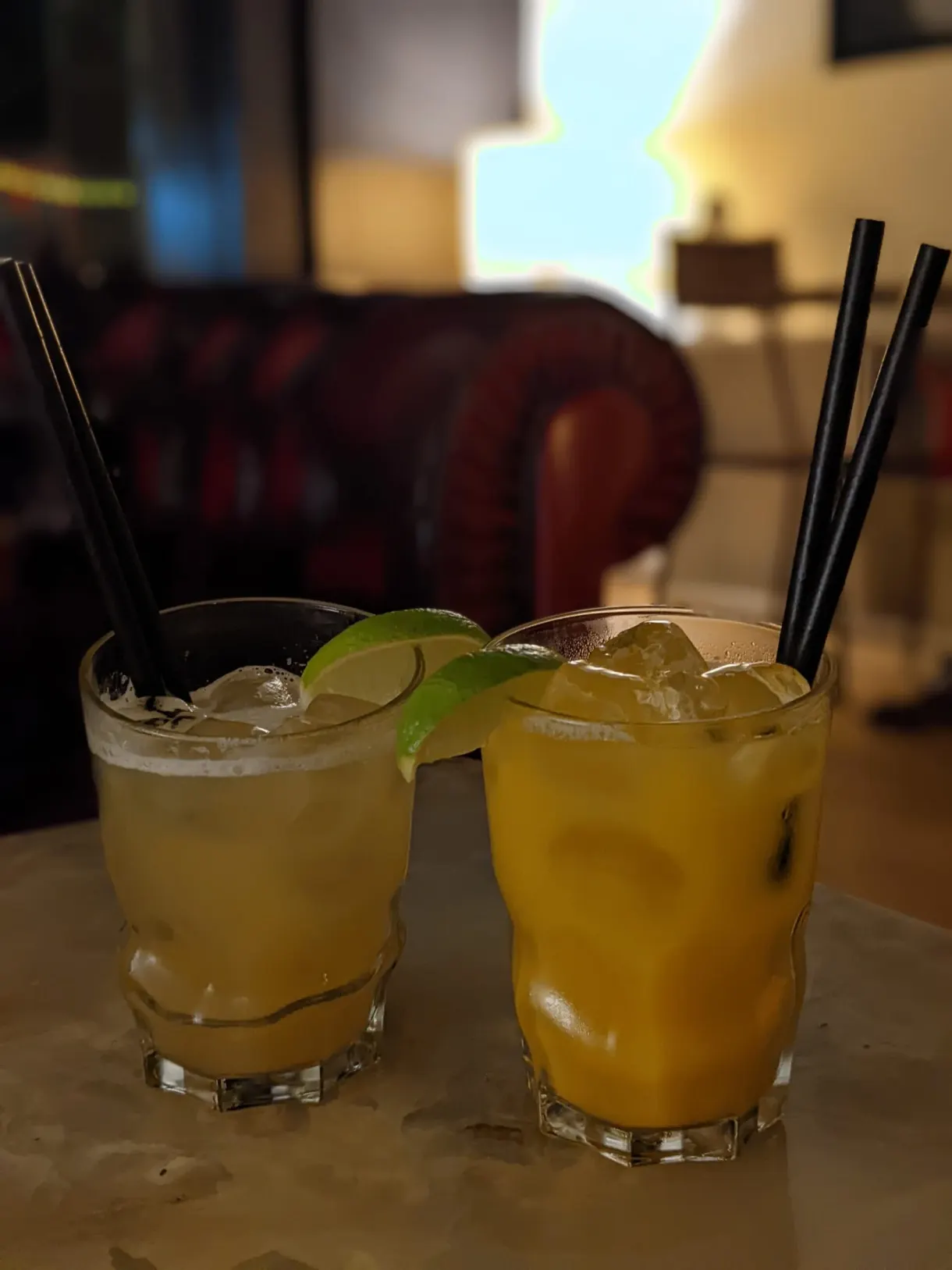 Deux cocktails jaunes glacés posés sur une table de bar
