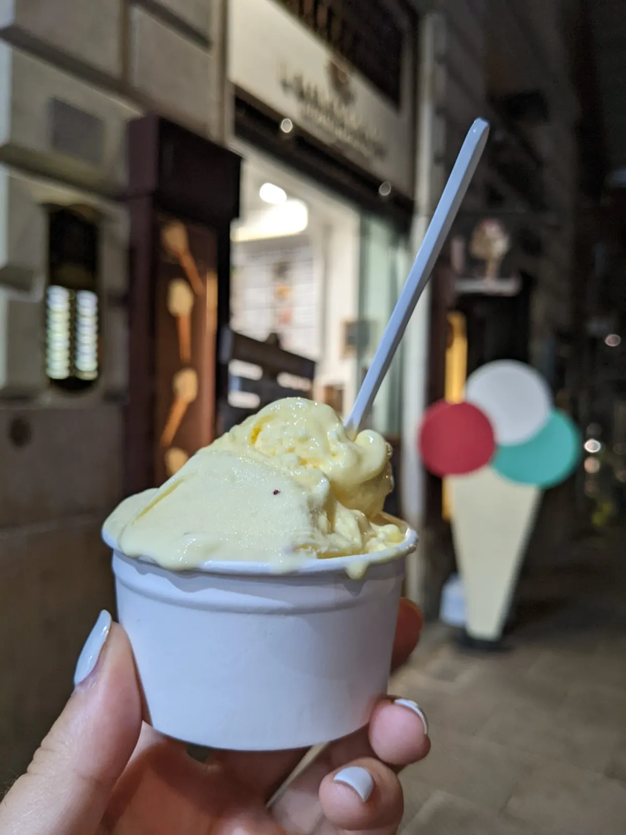 Boule jaune pâle tenue devant la vitrine du glacier