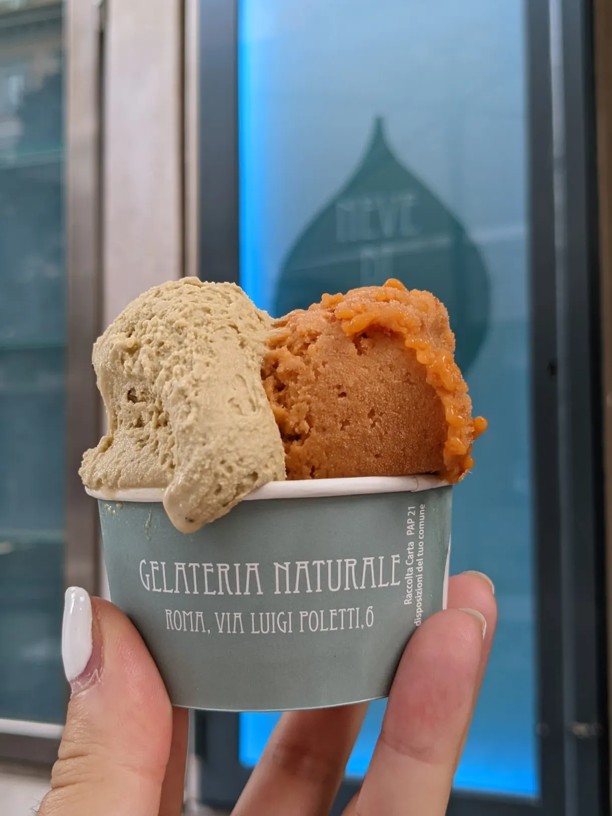 Deux boules beige et orange devant une vitrine bleutée