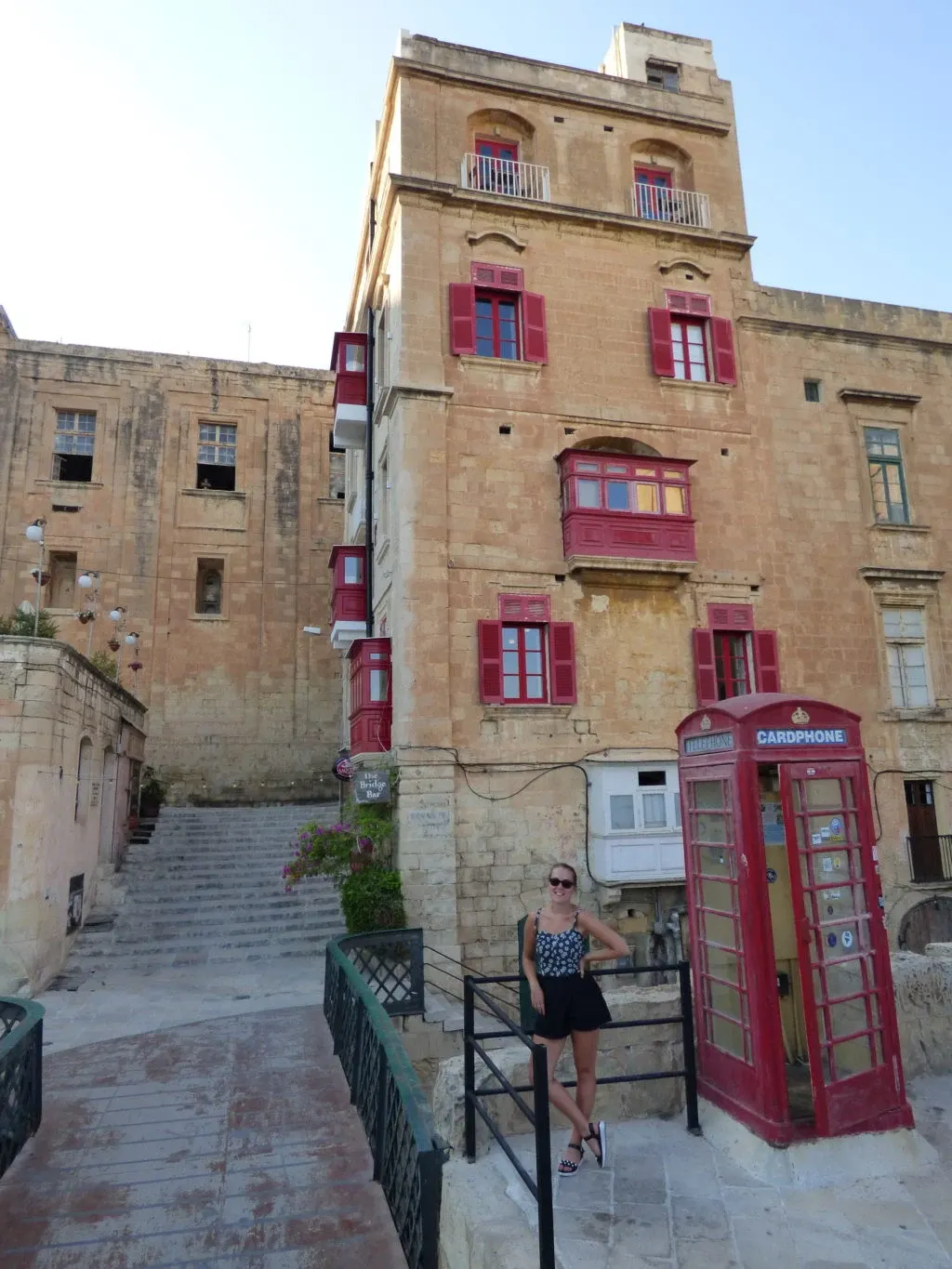 Woman near a red telephone box at the top of a staircase