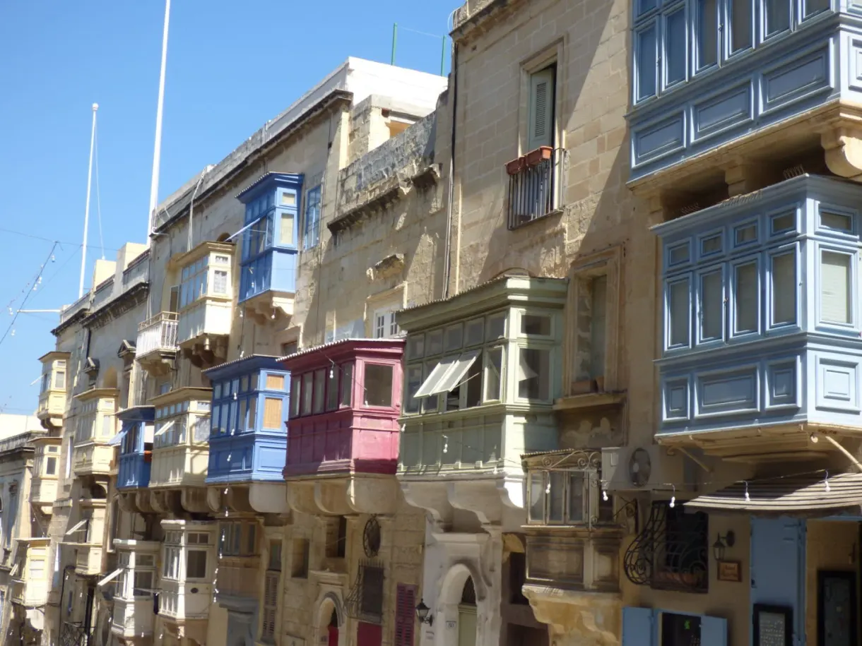 Row of colourful balconies on a facade of golden stone