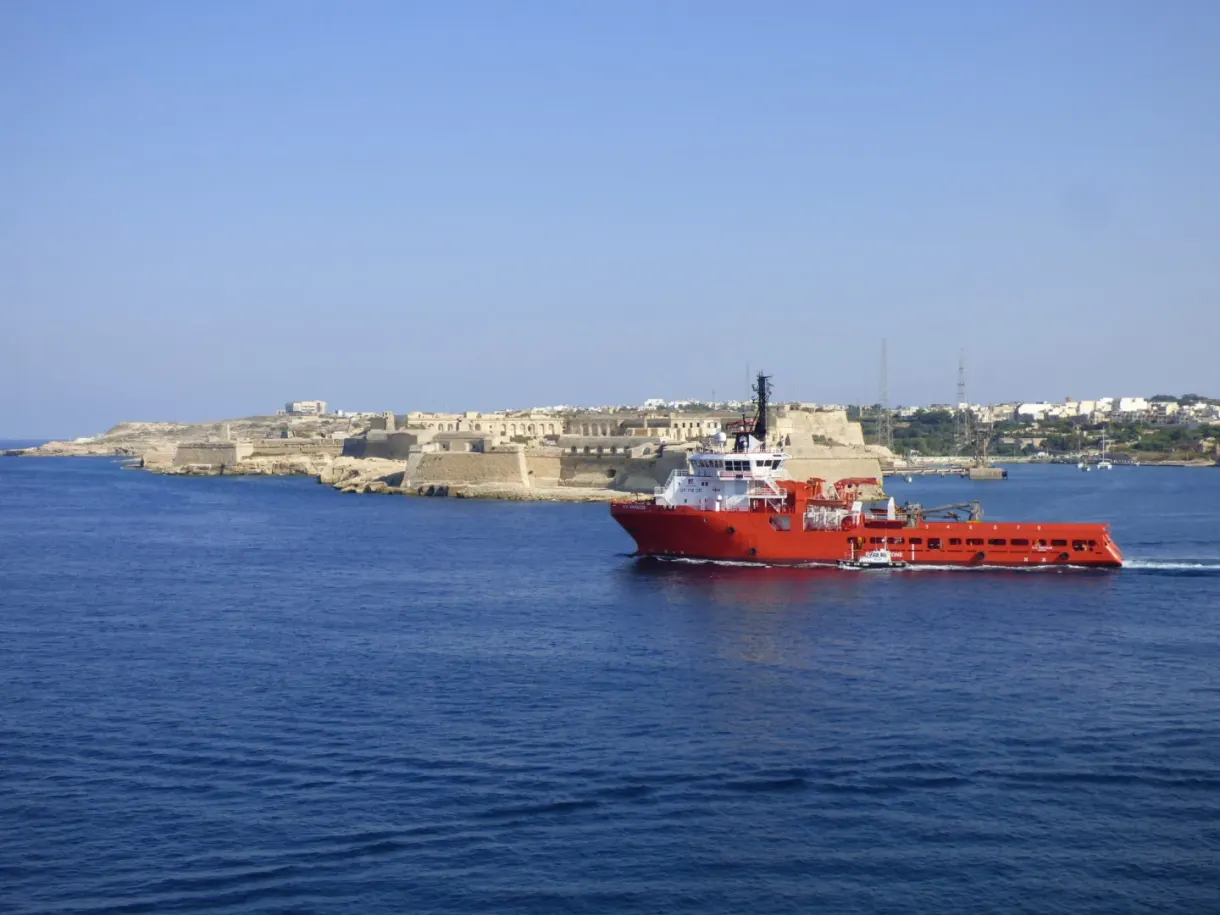 Red supply ship passing in front of the fortifications