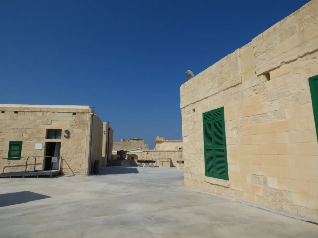 Stone buildings with green shutters inside the fort walls
