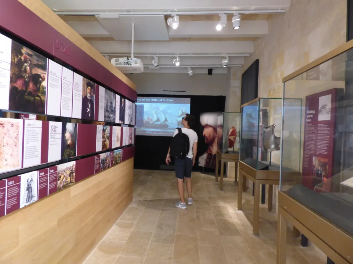 Visitor in front of the red panels of the museum exhibition