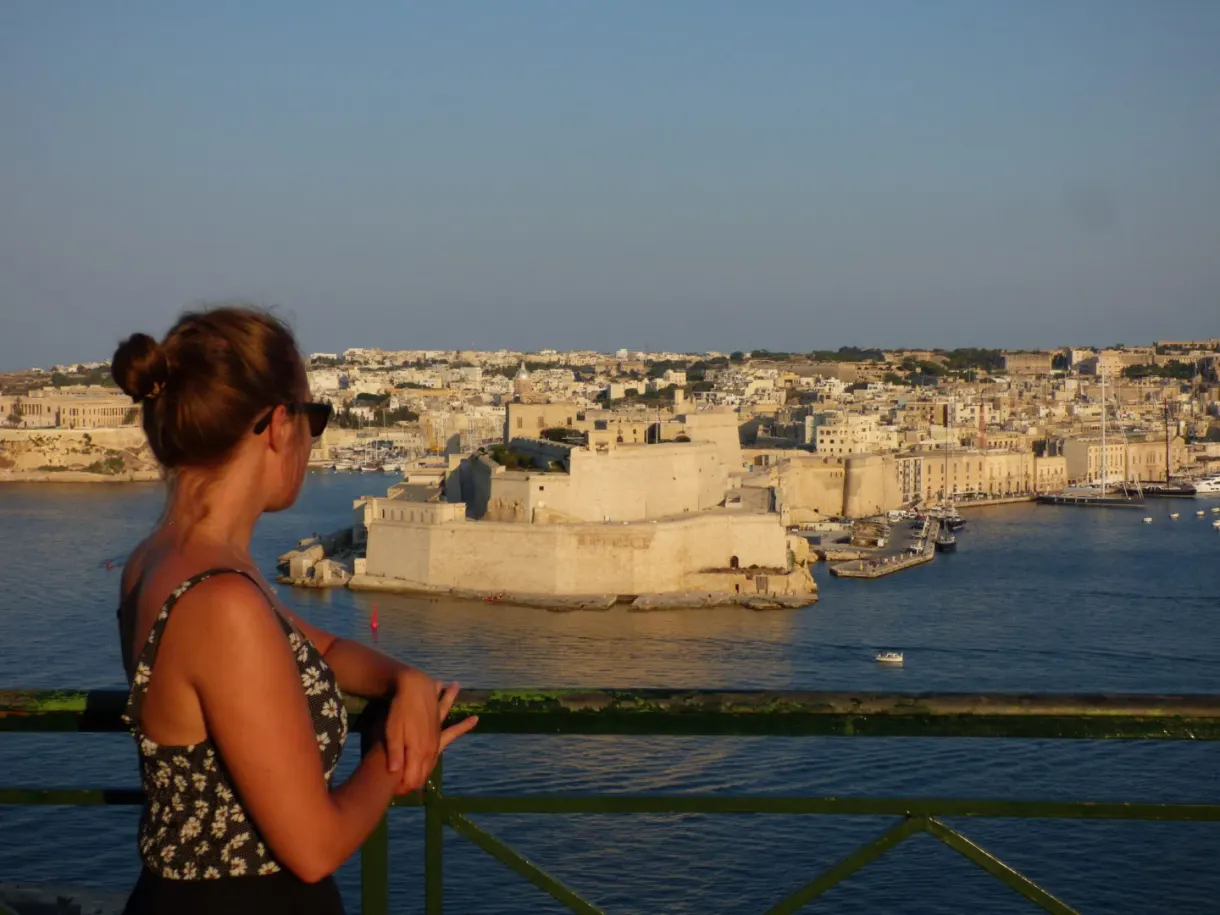 Woman leaning on the balustrade facing the fort opposite