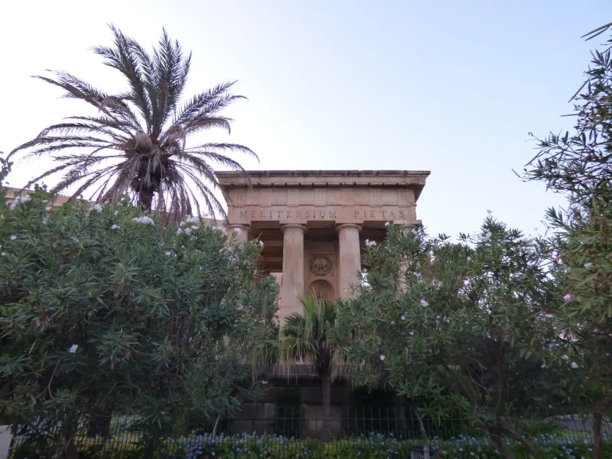 Neoclassical temple surrounded by palm trees and oleanders