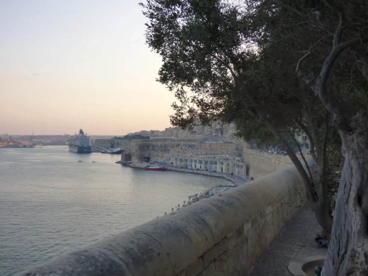 The harbour at dusk seen over the parapet of the garden