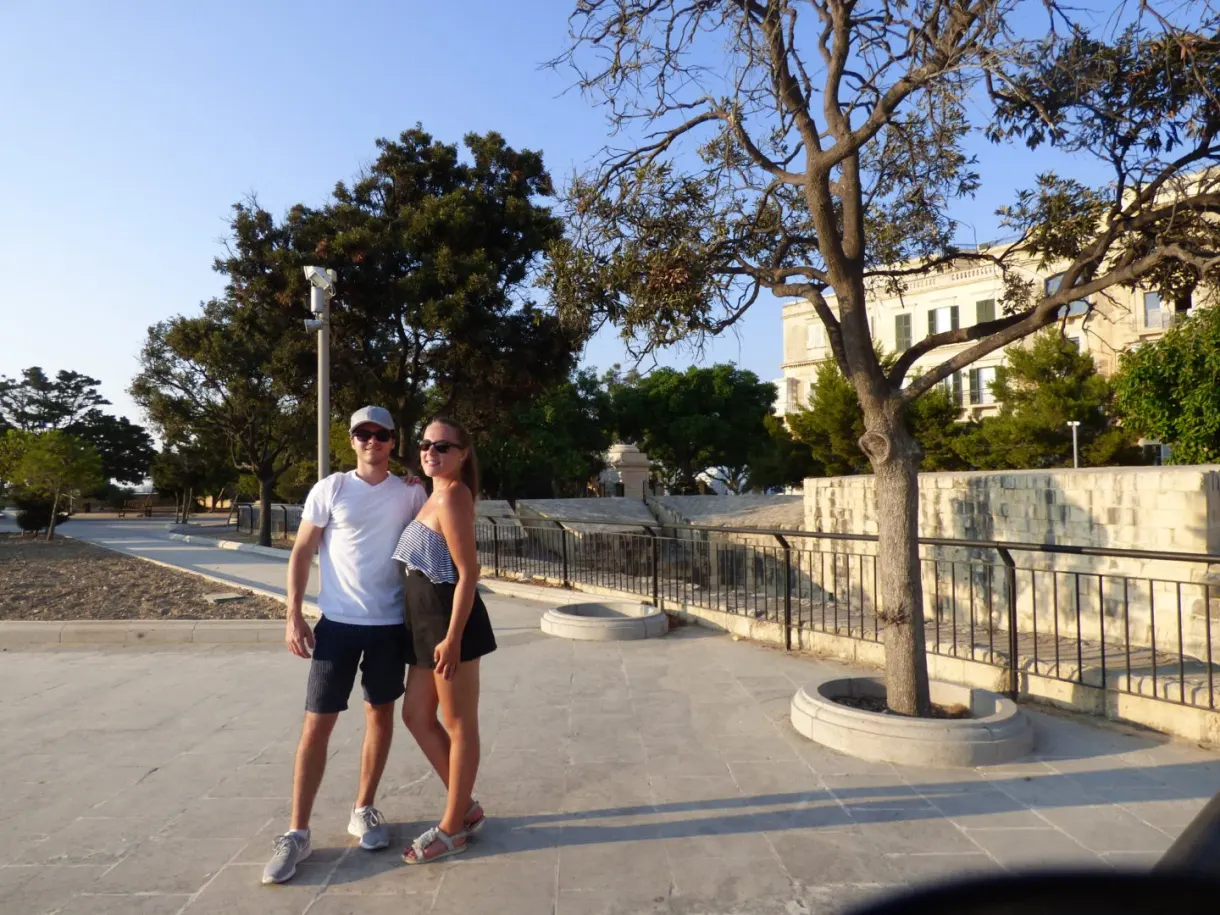 Couple posing on the tree lined esplanade of the garden