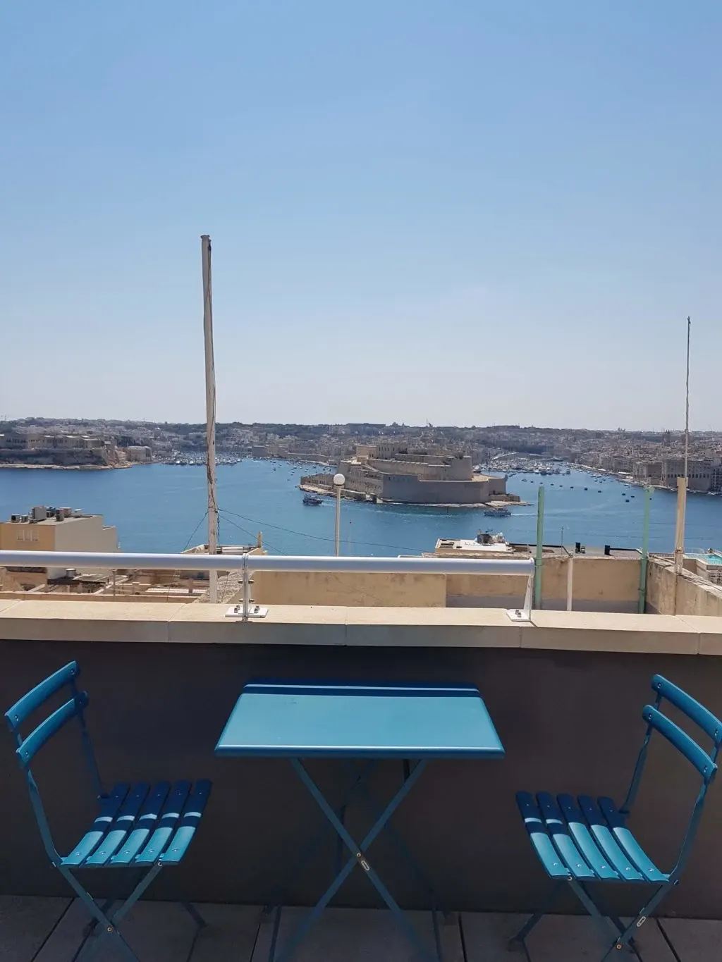 Blue table and chairs on the terrace facing the harbour