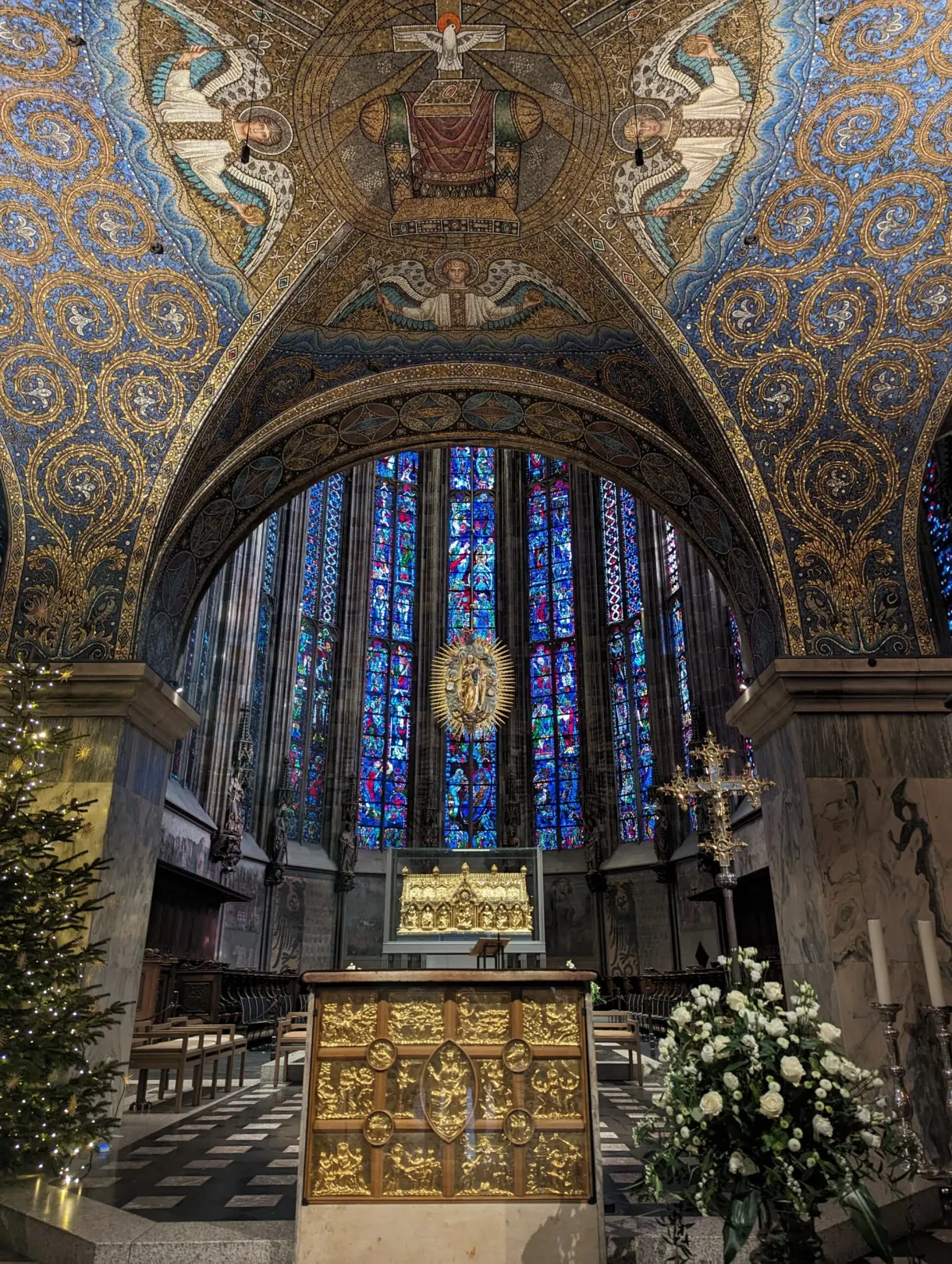 Stained-glass windows of the Gothic choir above the gilded altar