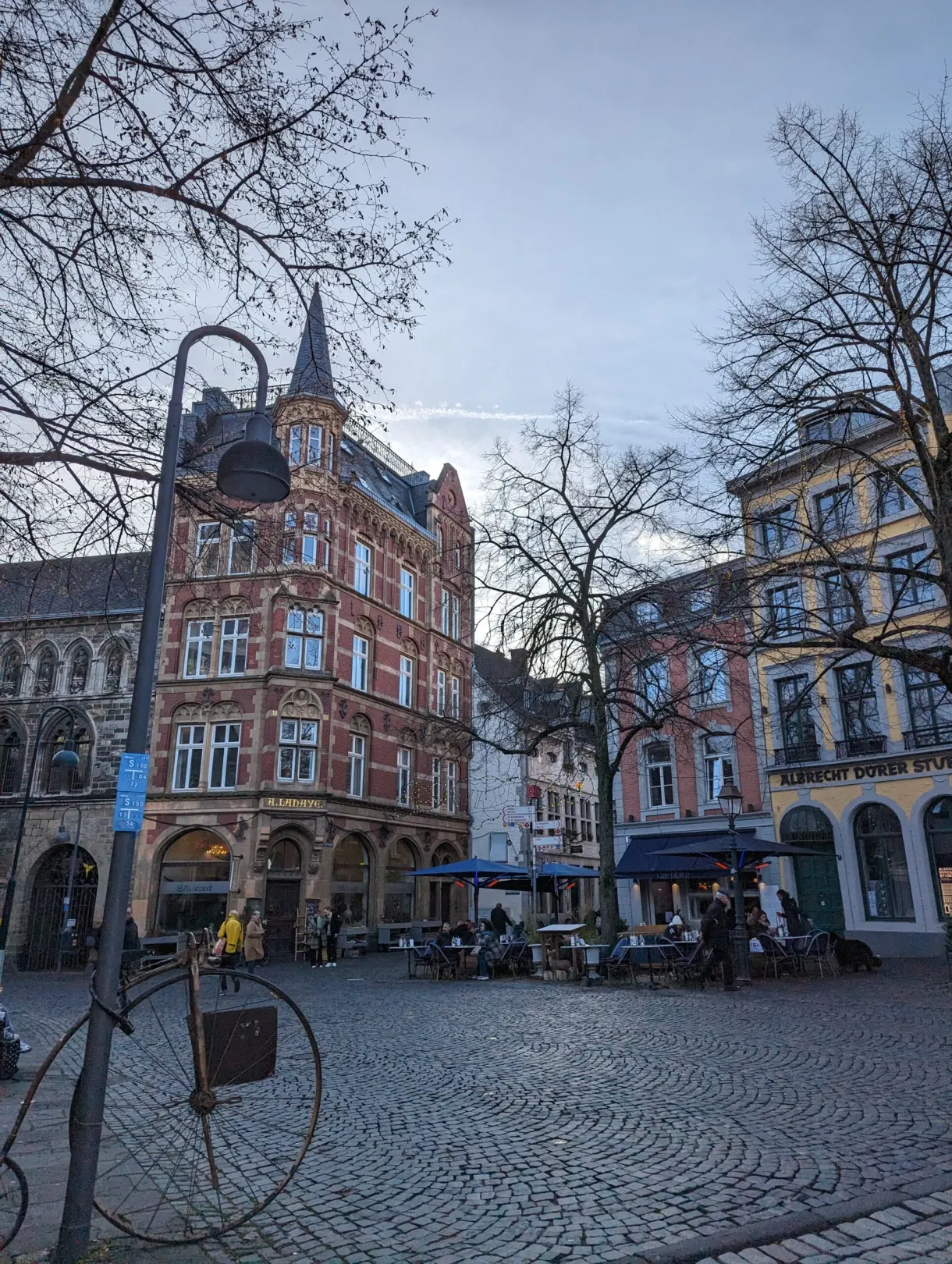 Cobbled square lined with old houses under bare trees