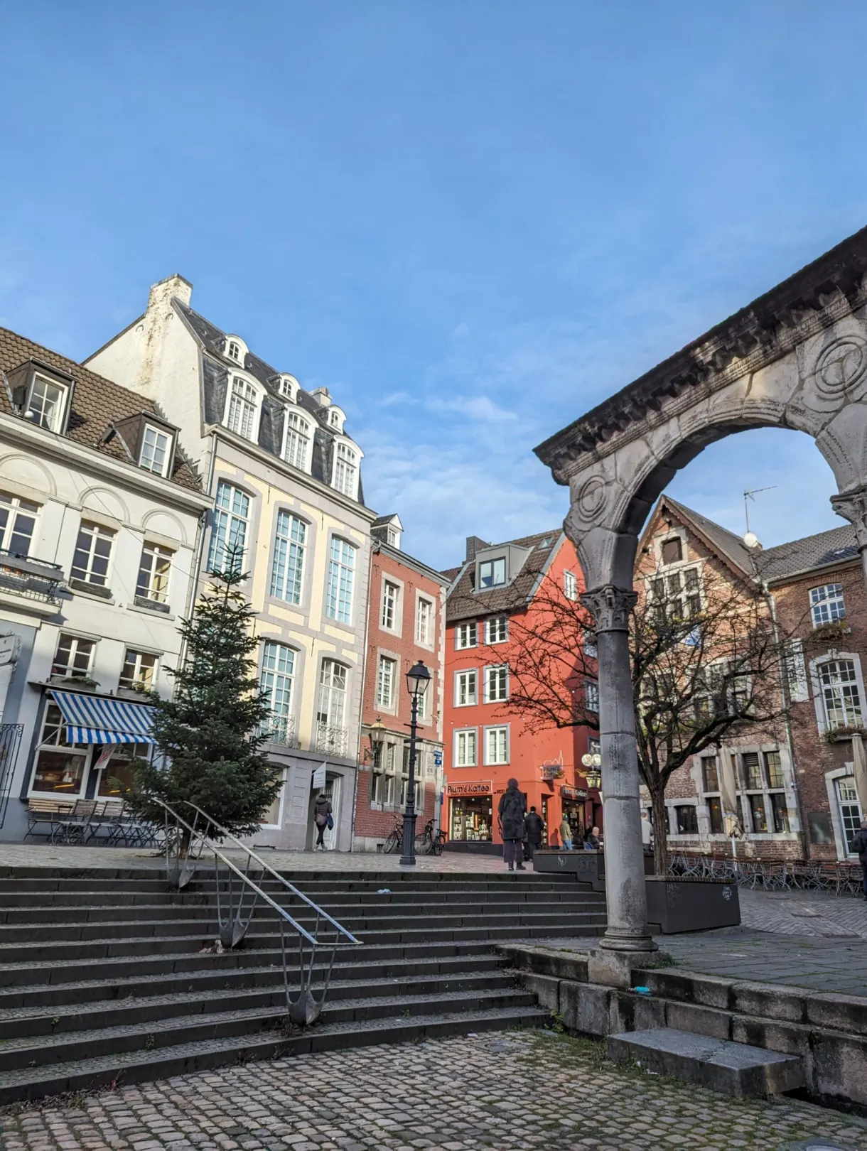 Stone arcades and colorful facades around a Christmas tree