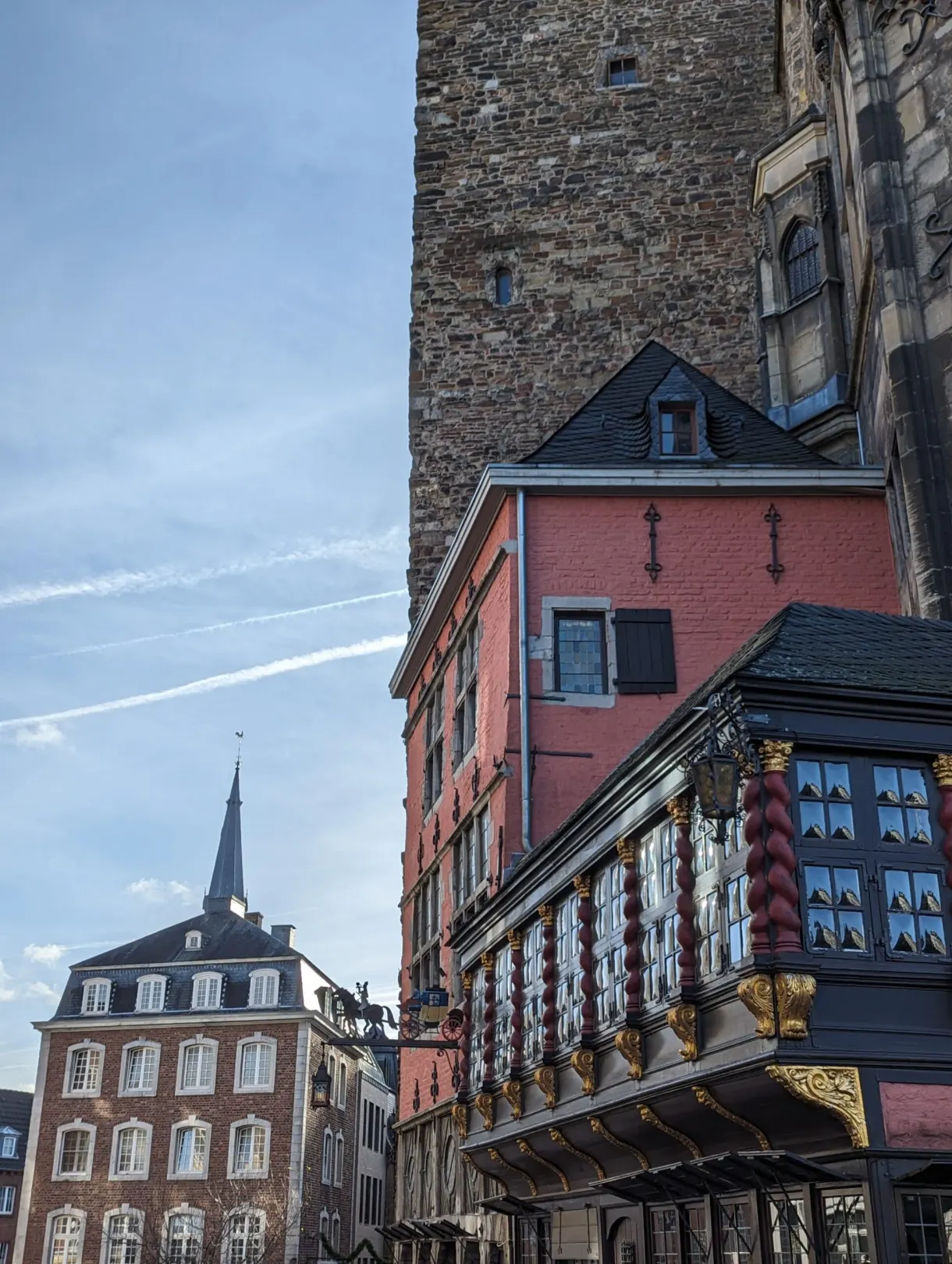 Ornate balcony and colorful houses at the foot of a stone tower