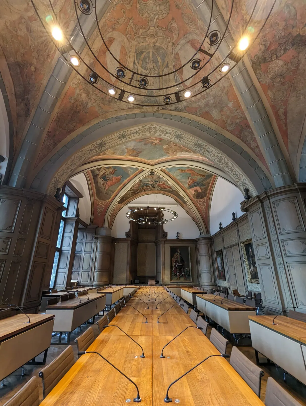 Large vaulted hall with its wall frescoes, tables lined up