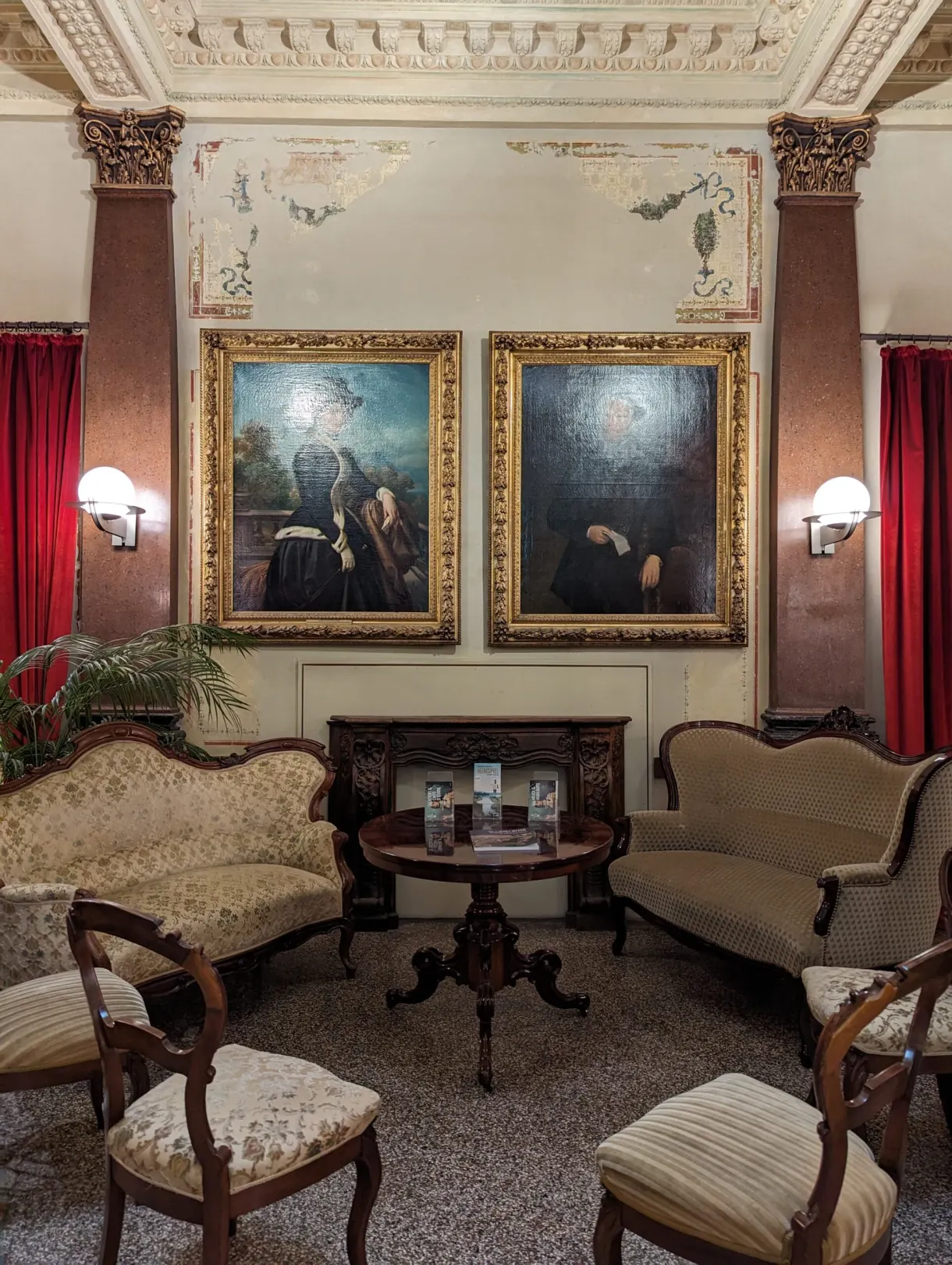 Period room in an art museum with paintings and antique armchairs