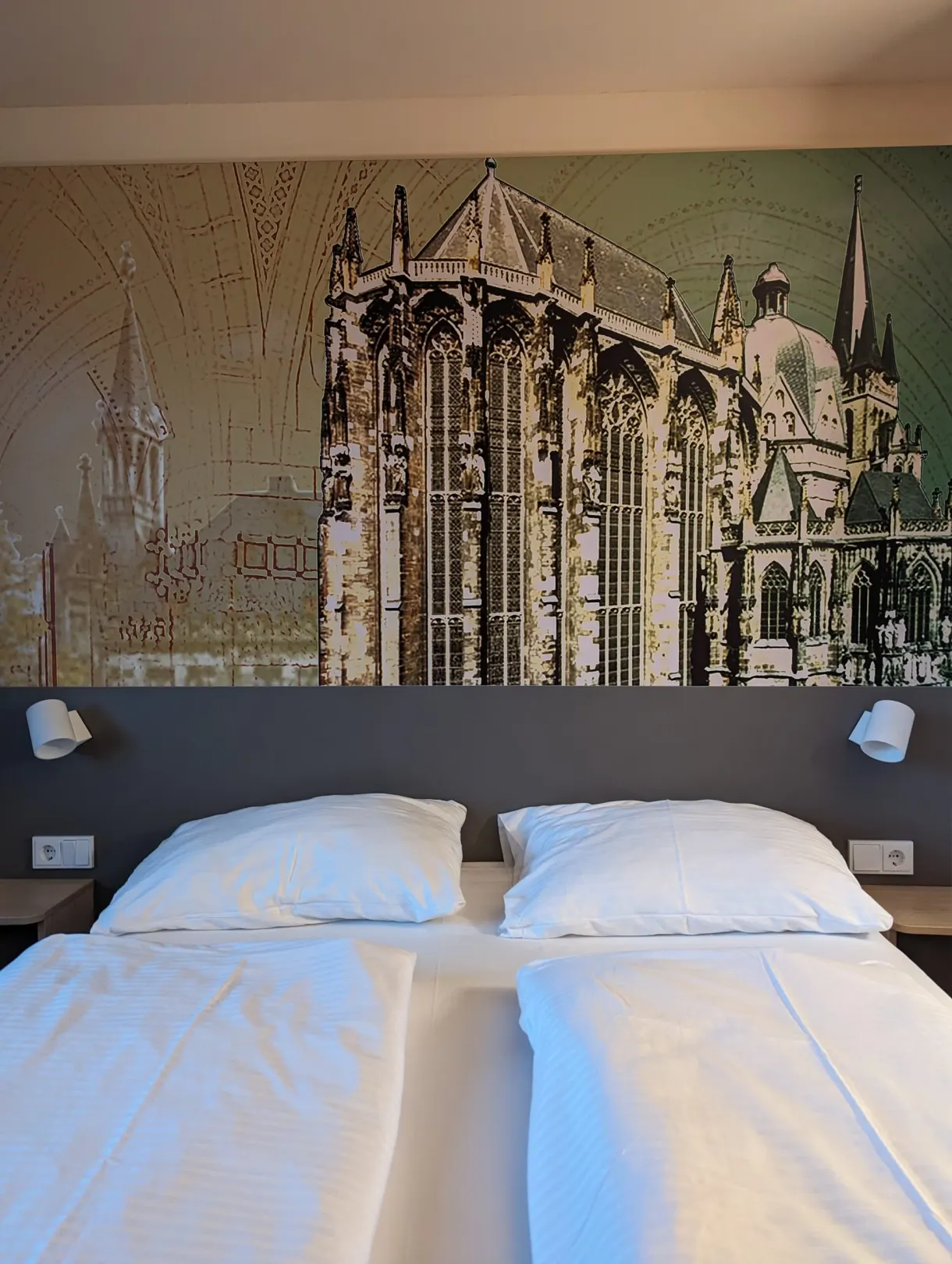 Hotel bed facing a mural of the cathedral