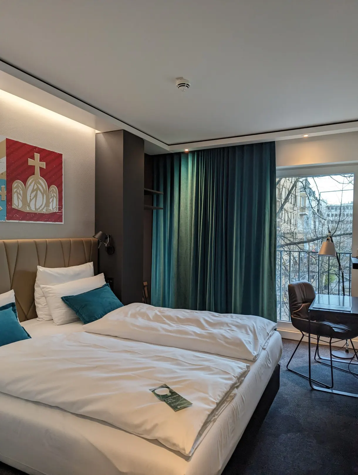Room with fir-green curtains opening onto a small balcony