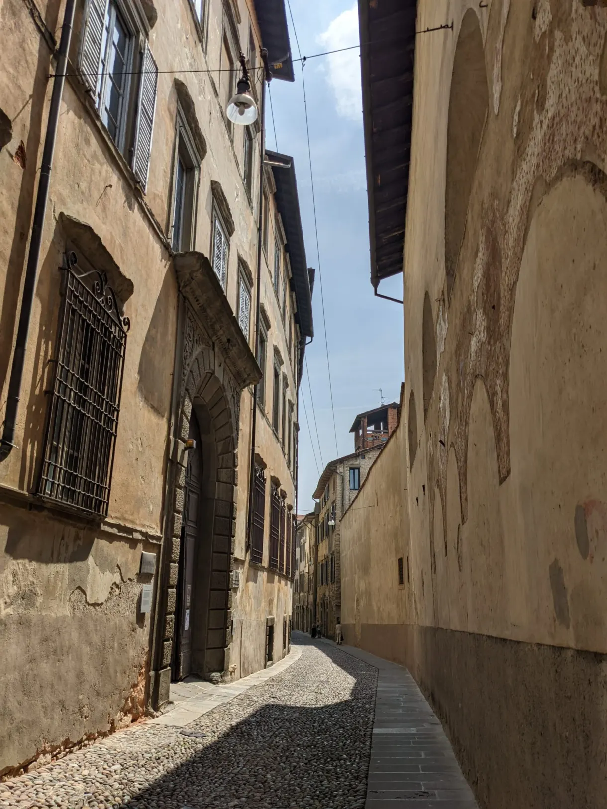 Narrow sloping lane between tall ochre walls