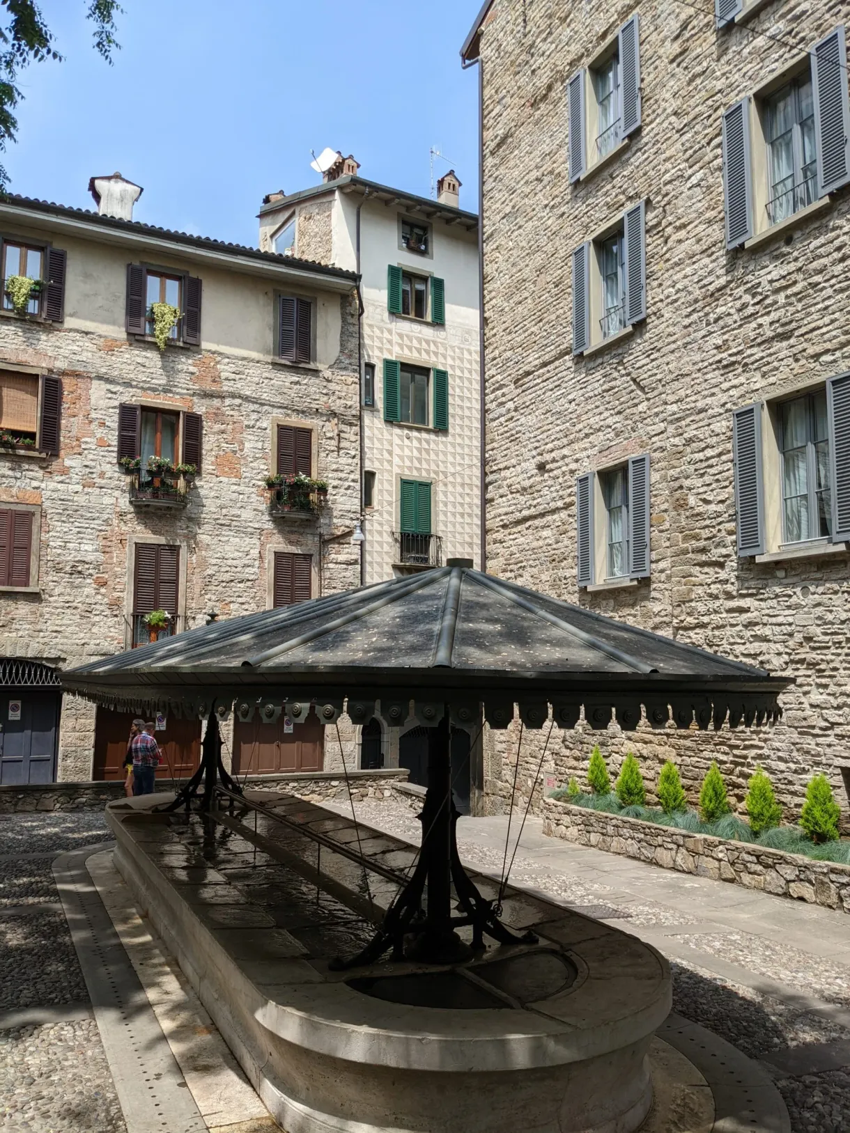 Old covered stone washhouse on a small square in the upper town