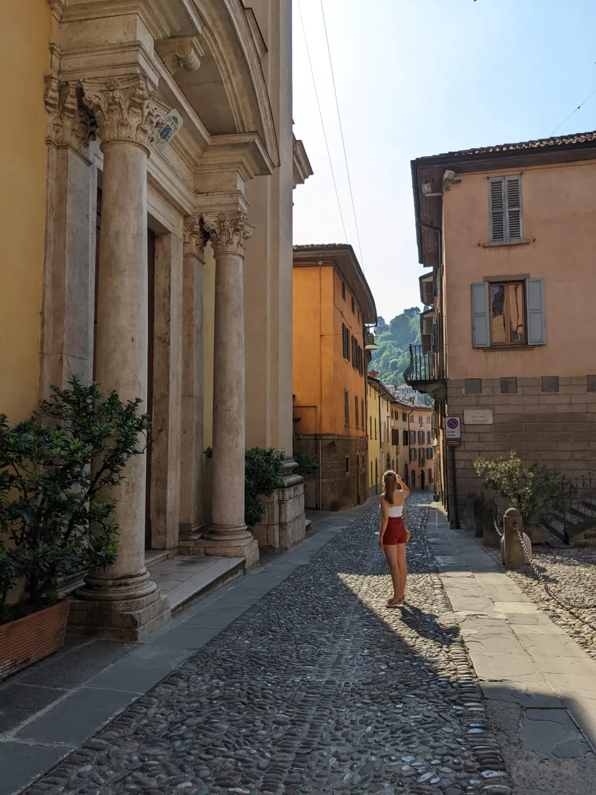 Passer-by in red in a street lined with columns