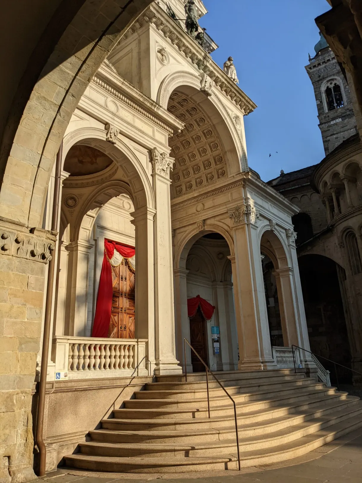 Columned porch and staircase leading to a red hanging
