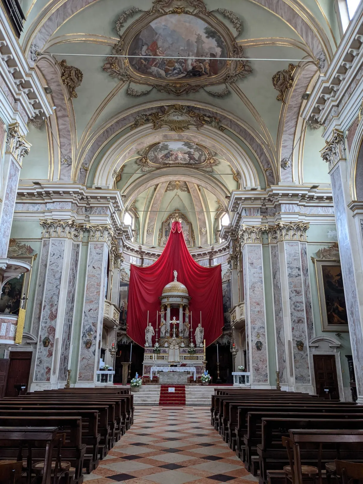 Baroque nave with a chequerboard floor and a red hanging