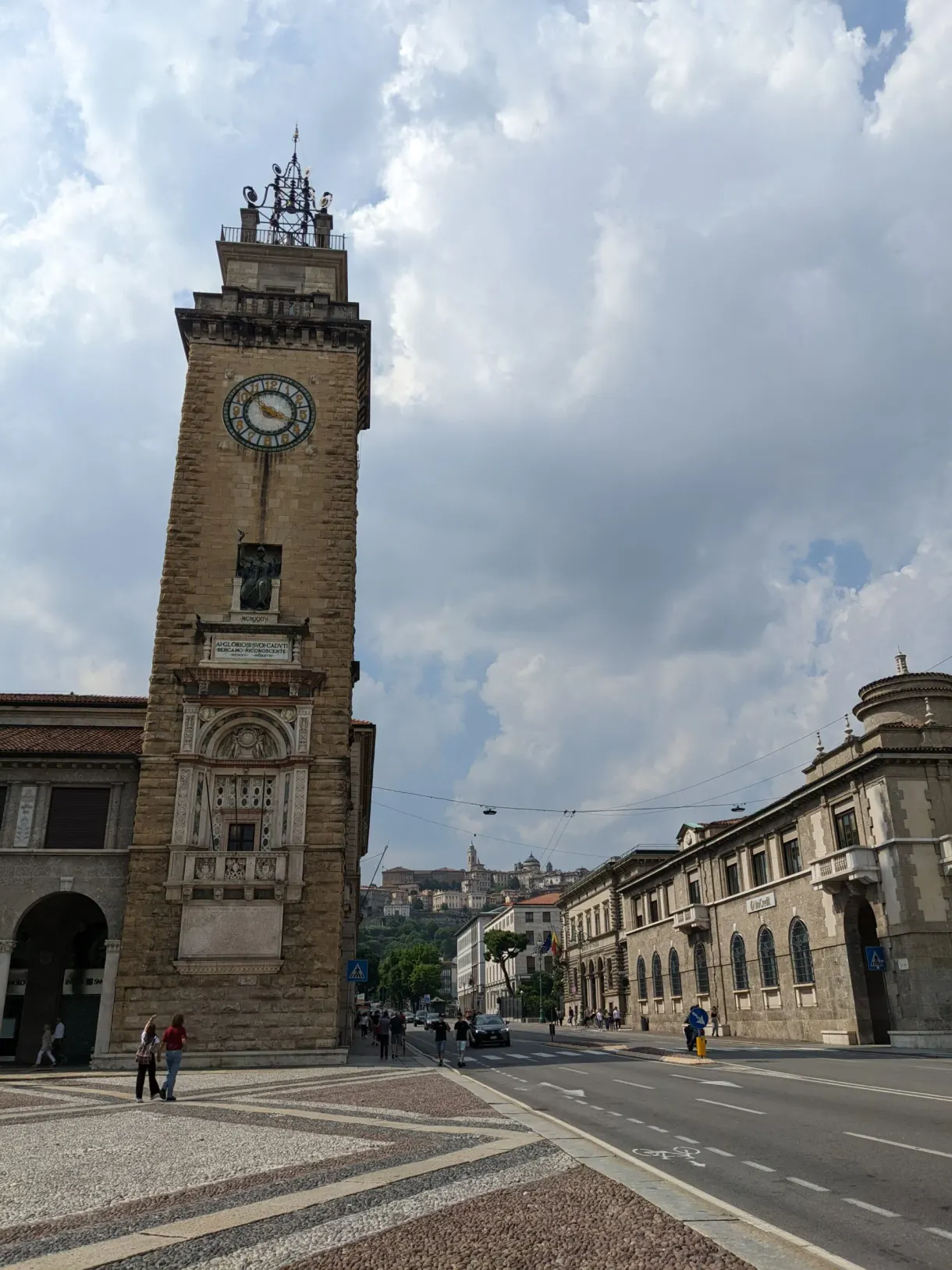 Brick tower overlooking a square with pale paving