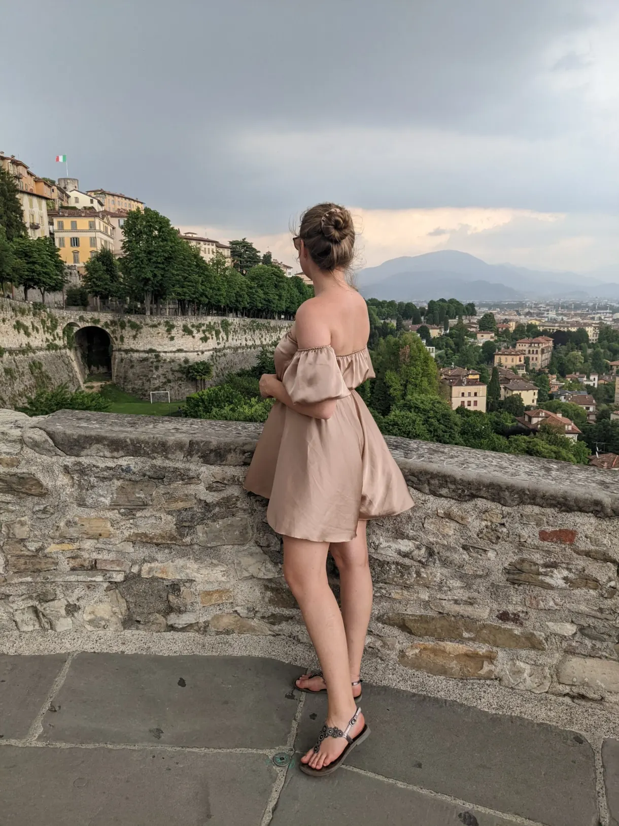 Woman seen from behind leaning on the rampart facing the panorama