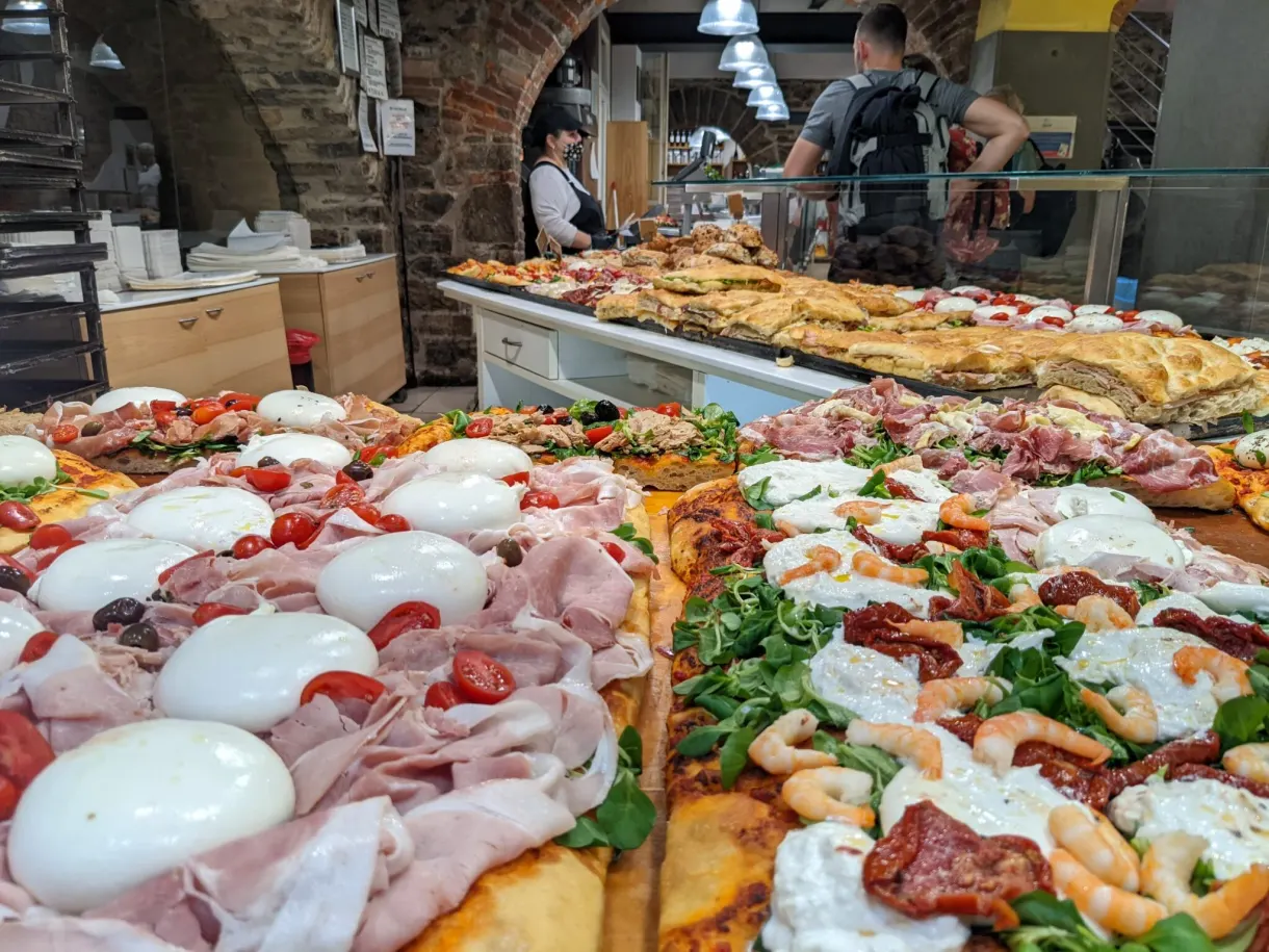 Display of topped focaccia slices behind a window