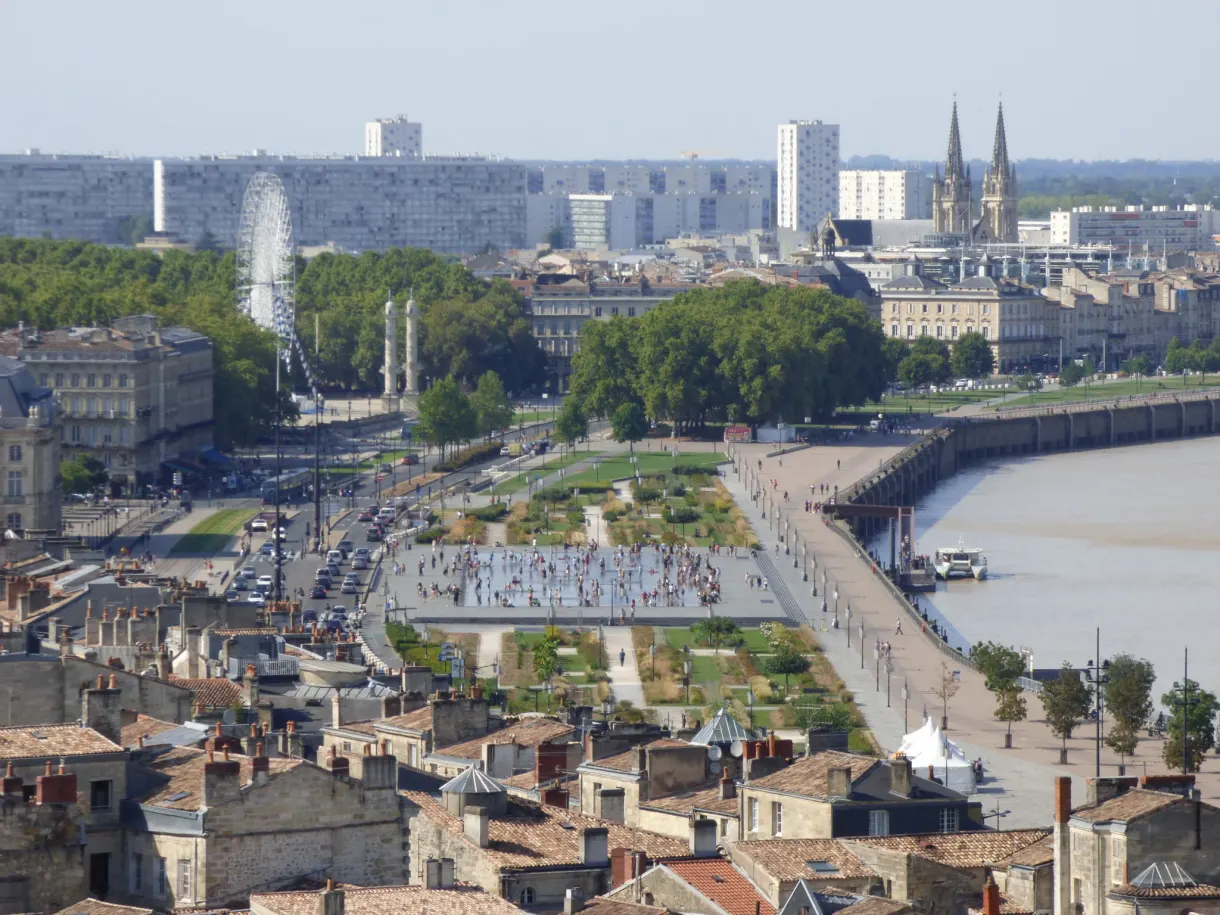 Quais et esplanade arborée le long du fleuve, grande roue au loin