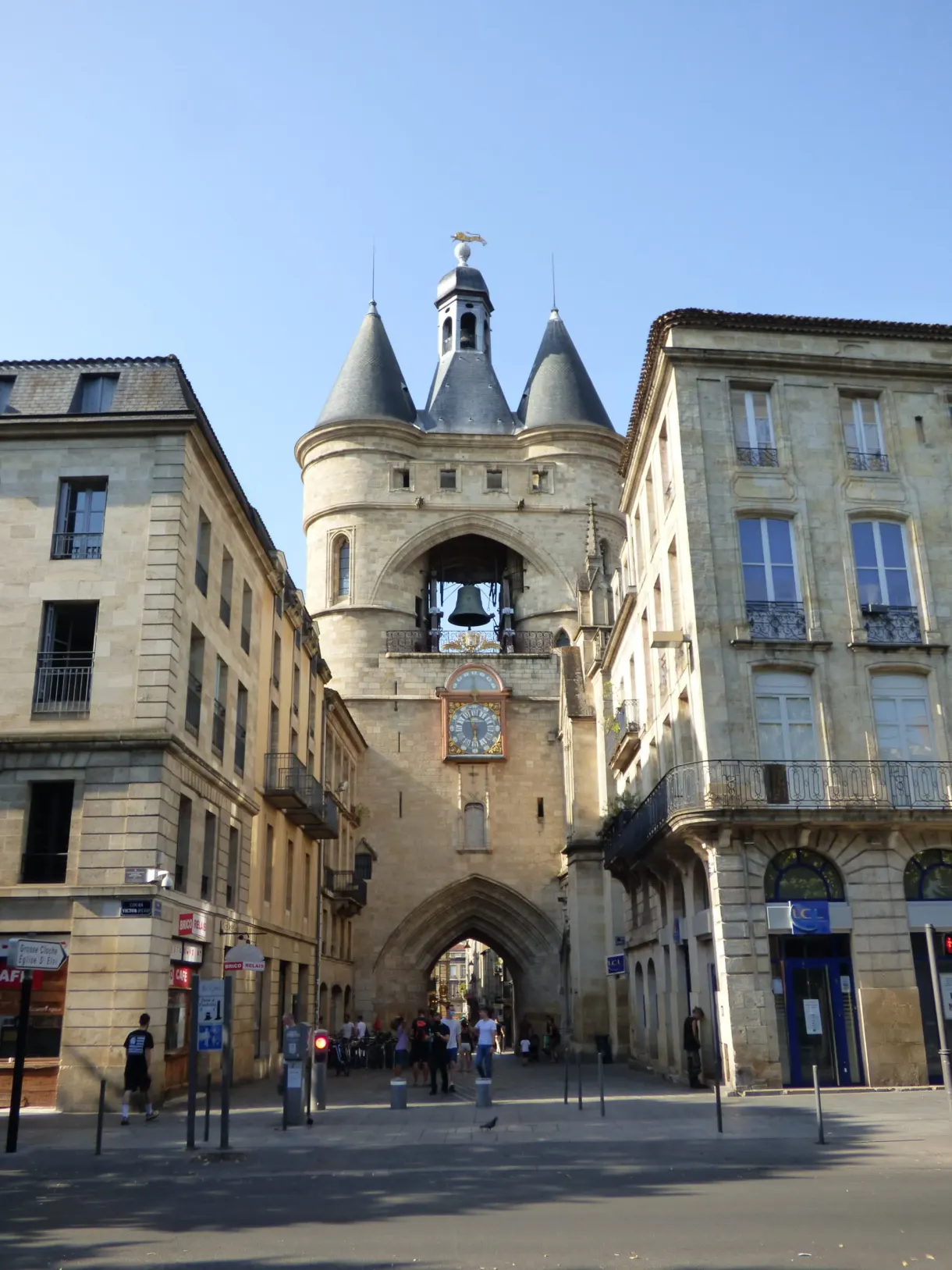 Beffroi médiéval à deux tourelles coiffées d'ardoise au bout d'une rue