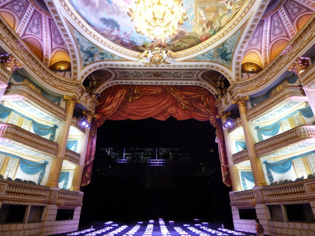 Salle à l'italienne aux loges bleu et or, rideau ouvert sur la scène