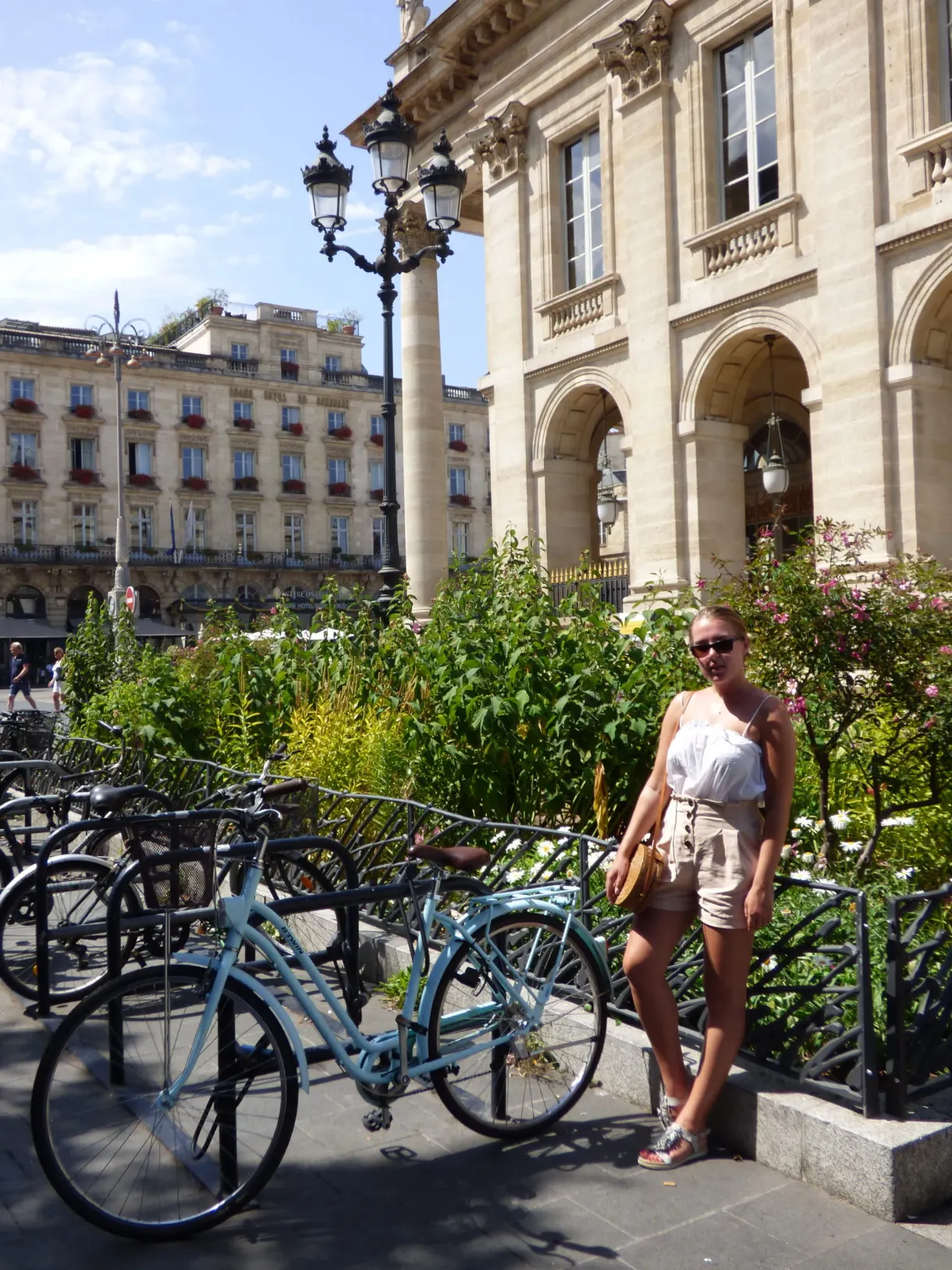 Femme adossée à des jardinières près de vélos en libre-service