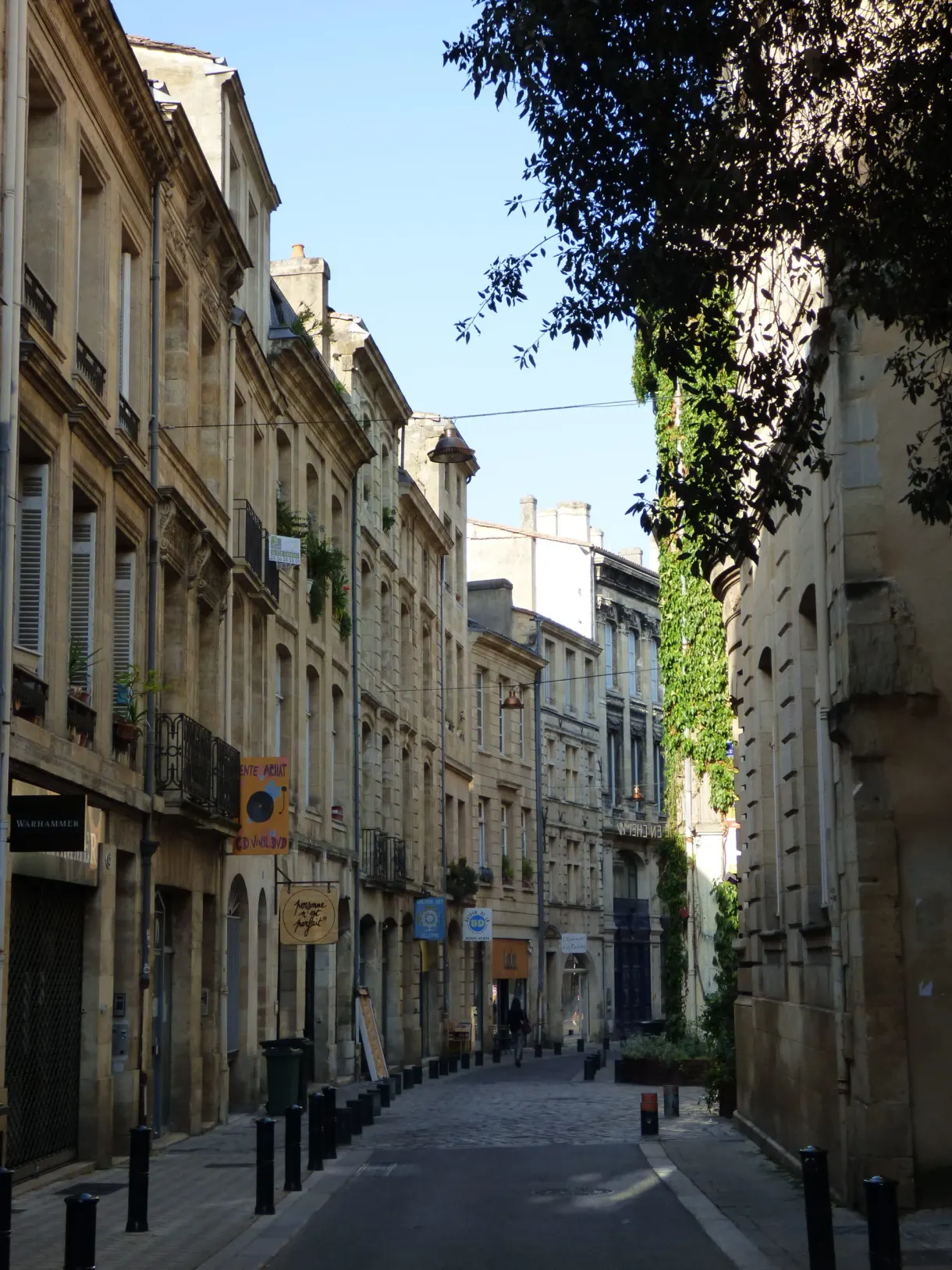 Rue calme d'immeubles en pierre blonde aux volets clos