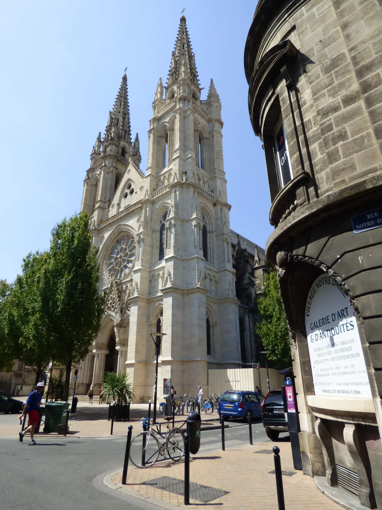 Église néogothique à deux flèches ajourées dominant une placette
