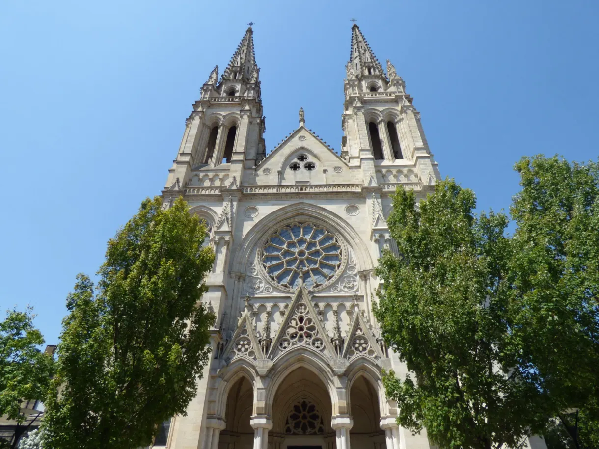 Contre-plongée sur la rosace et les clochetons d'une façade d'église