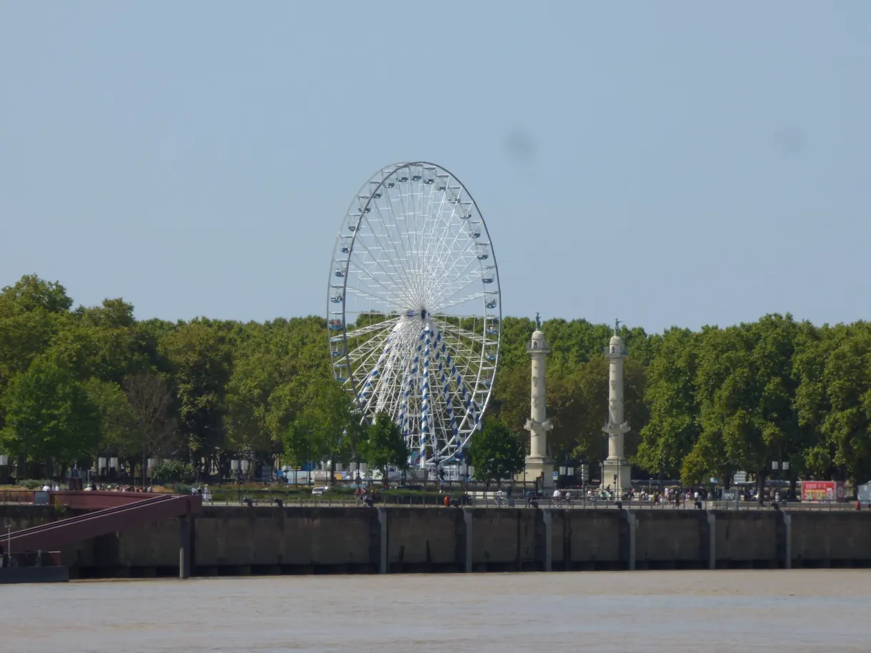 Grande roue blanche derrière les colonnes rostrales des Quinconces