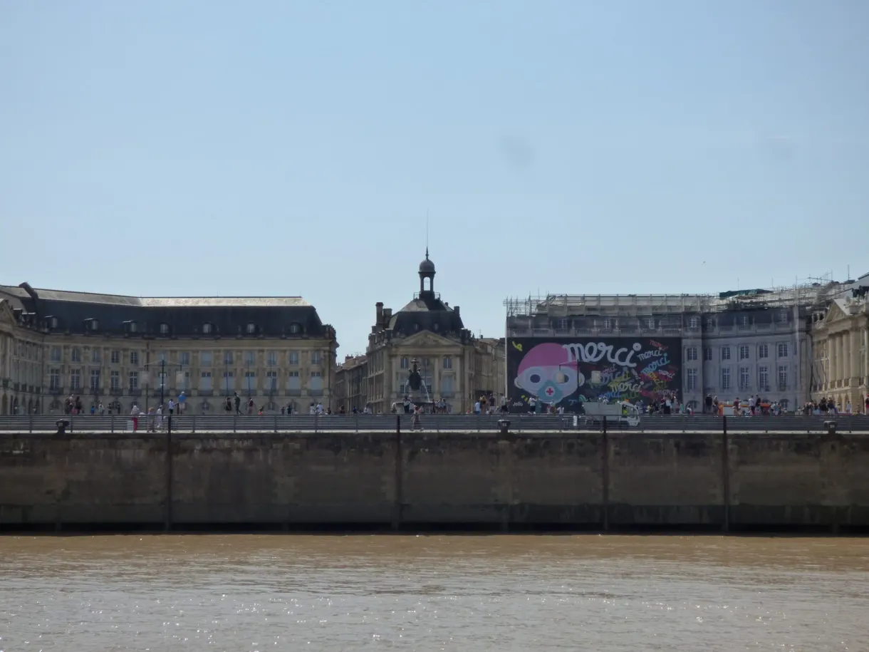 Façades classiques de la place de la Bourse alignées face au fleuve
