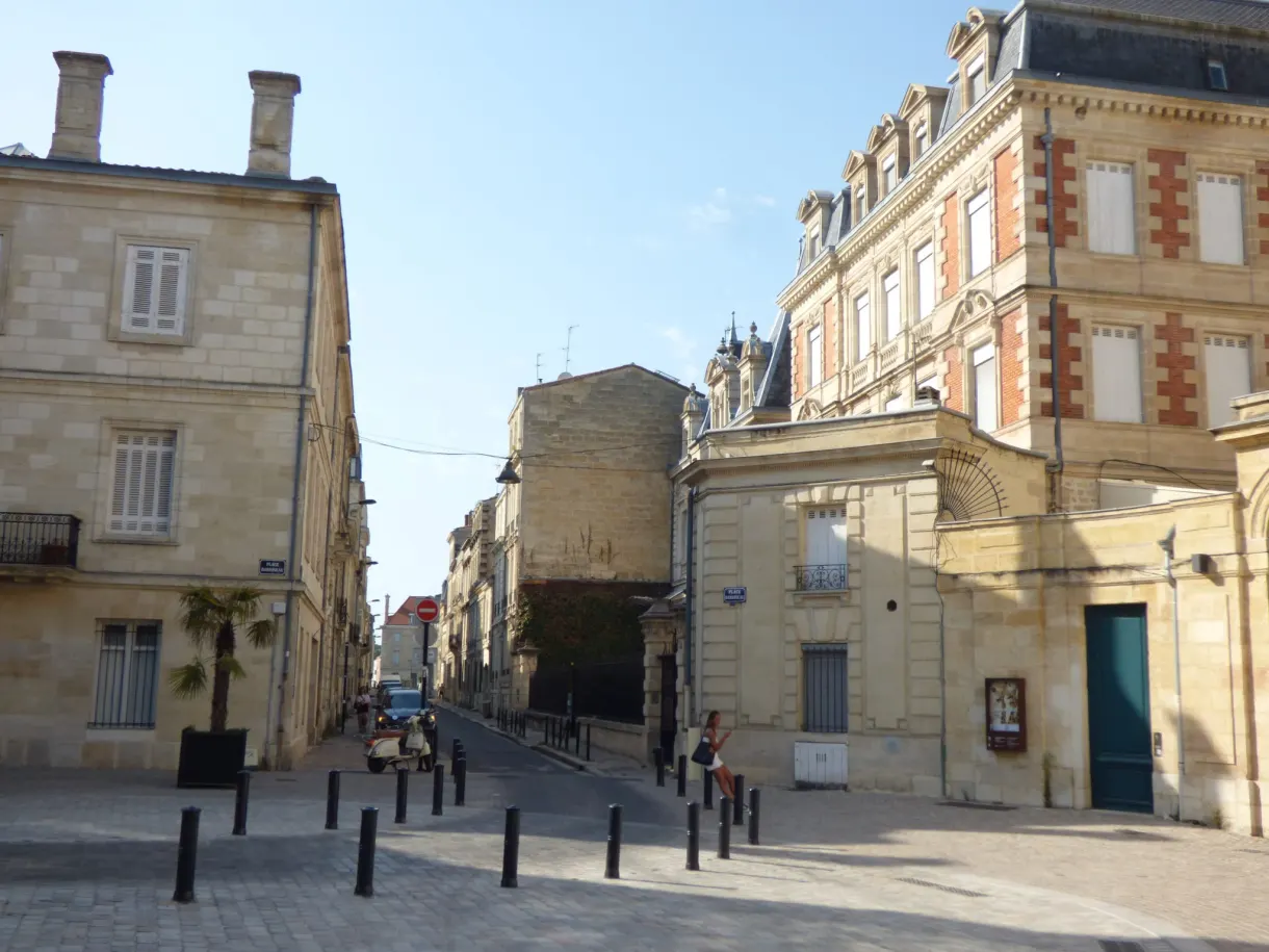 Ruelle bordée d'une façade de pierre et d'un immeuble de brique rouge