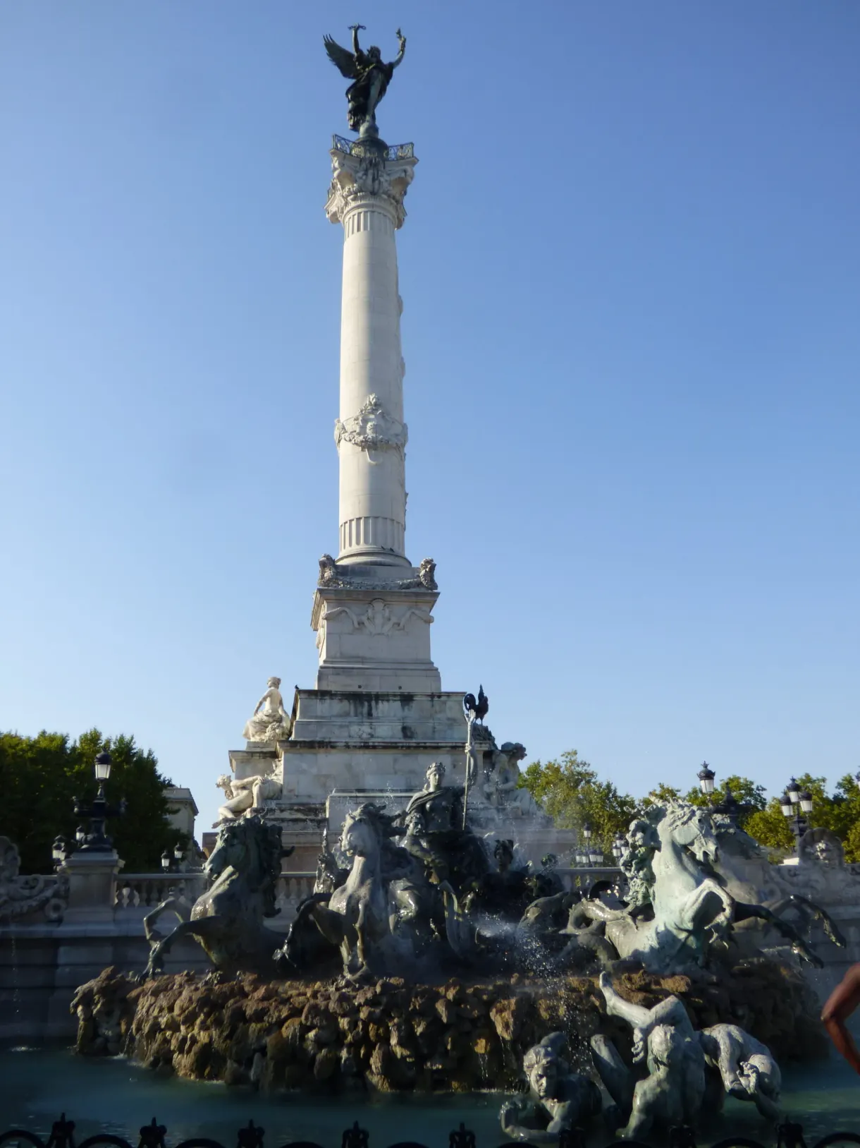 Colonne surmontée d'une statue dorée au-dessus d'une fontaine de bronze
