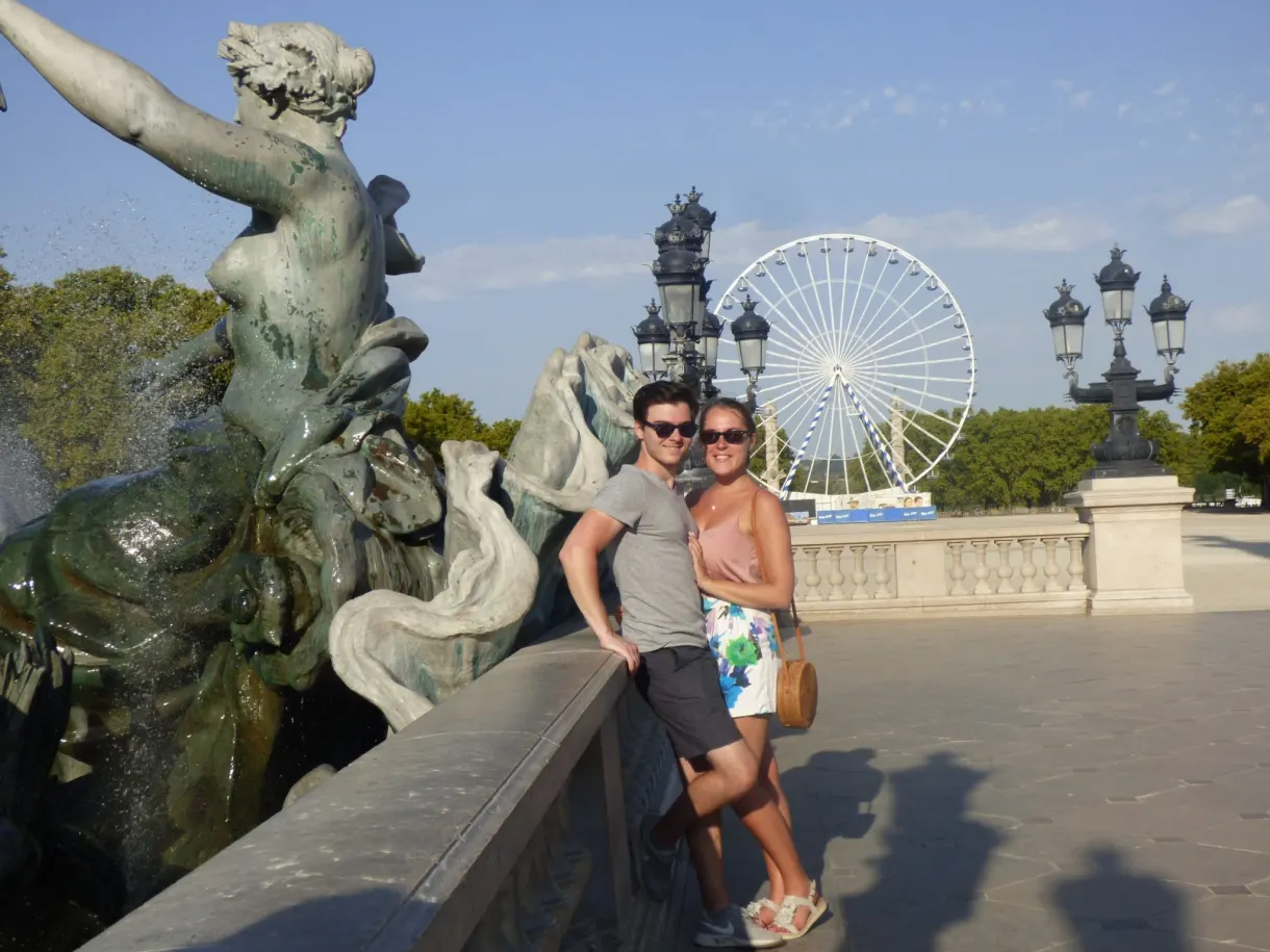 Couple posant devant la fontaine, grande roue en arrière-plan
