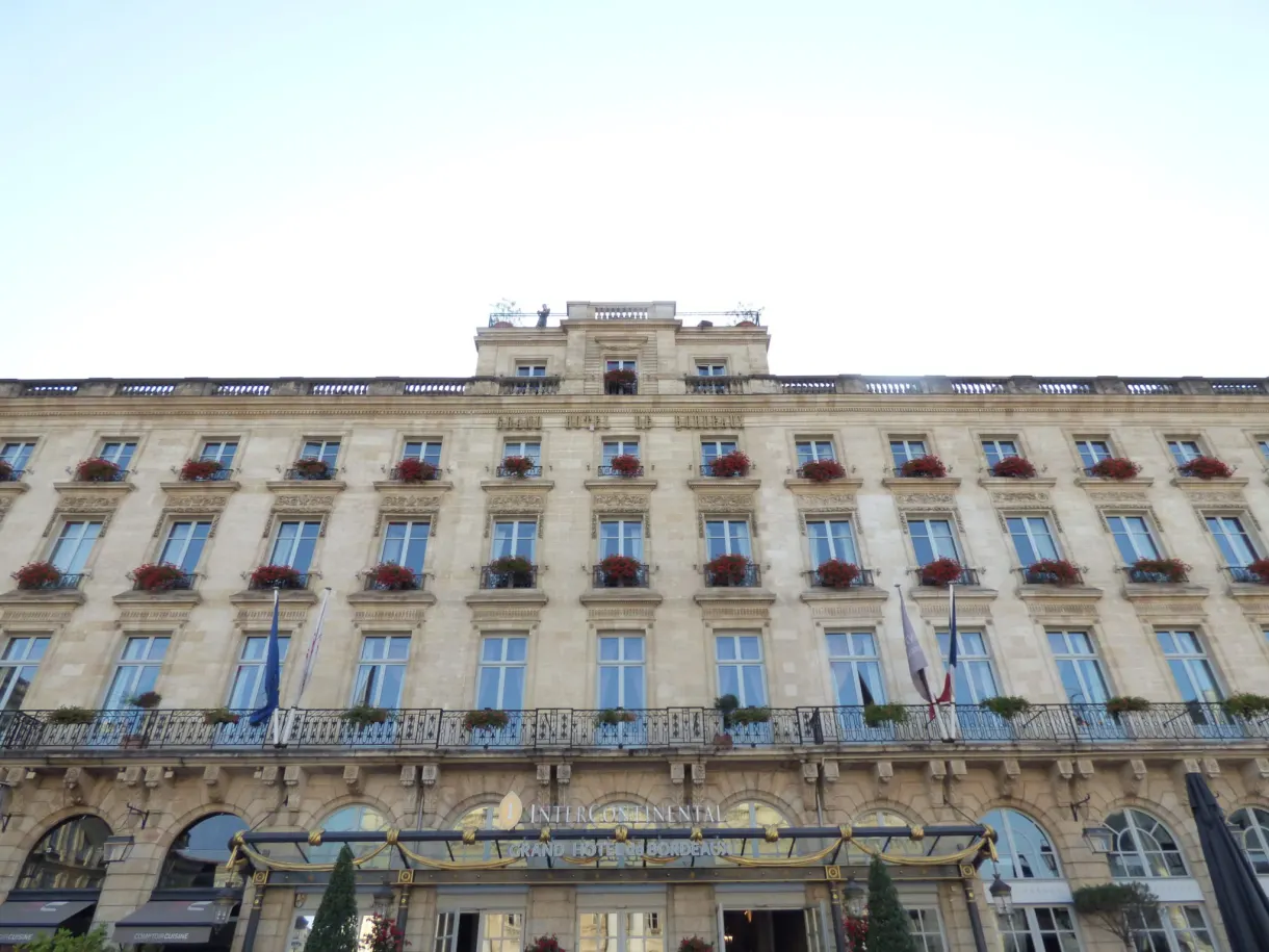 Façade d'un palace aux balcons fleuris de géraniums rouges