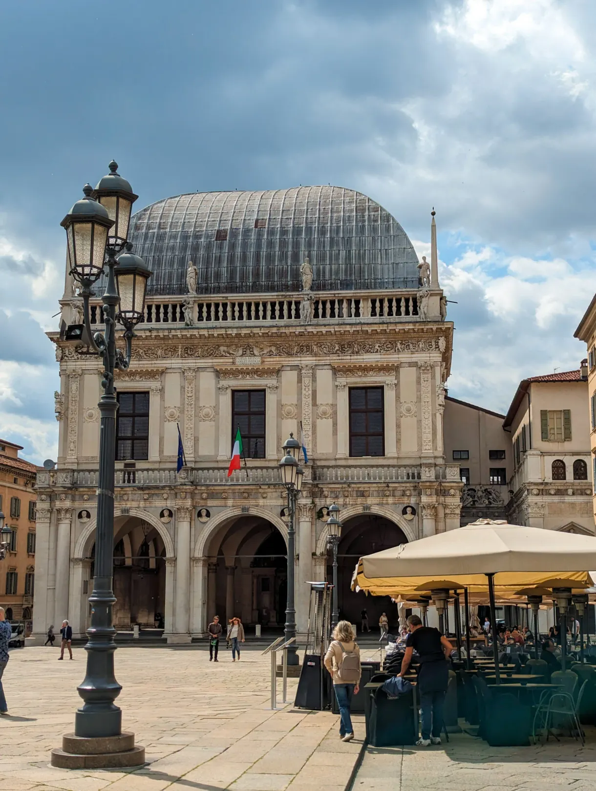 Palace with a curved roof and terraces on the Piazza della Loggia