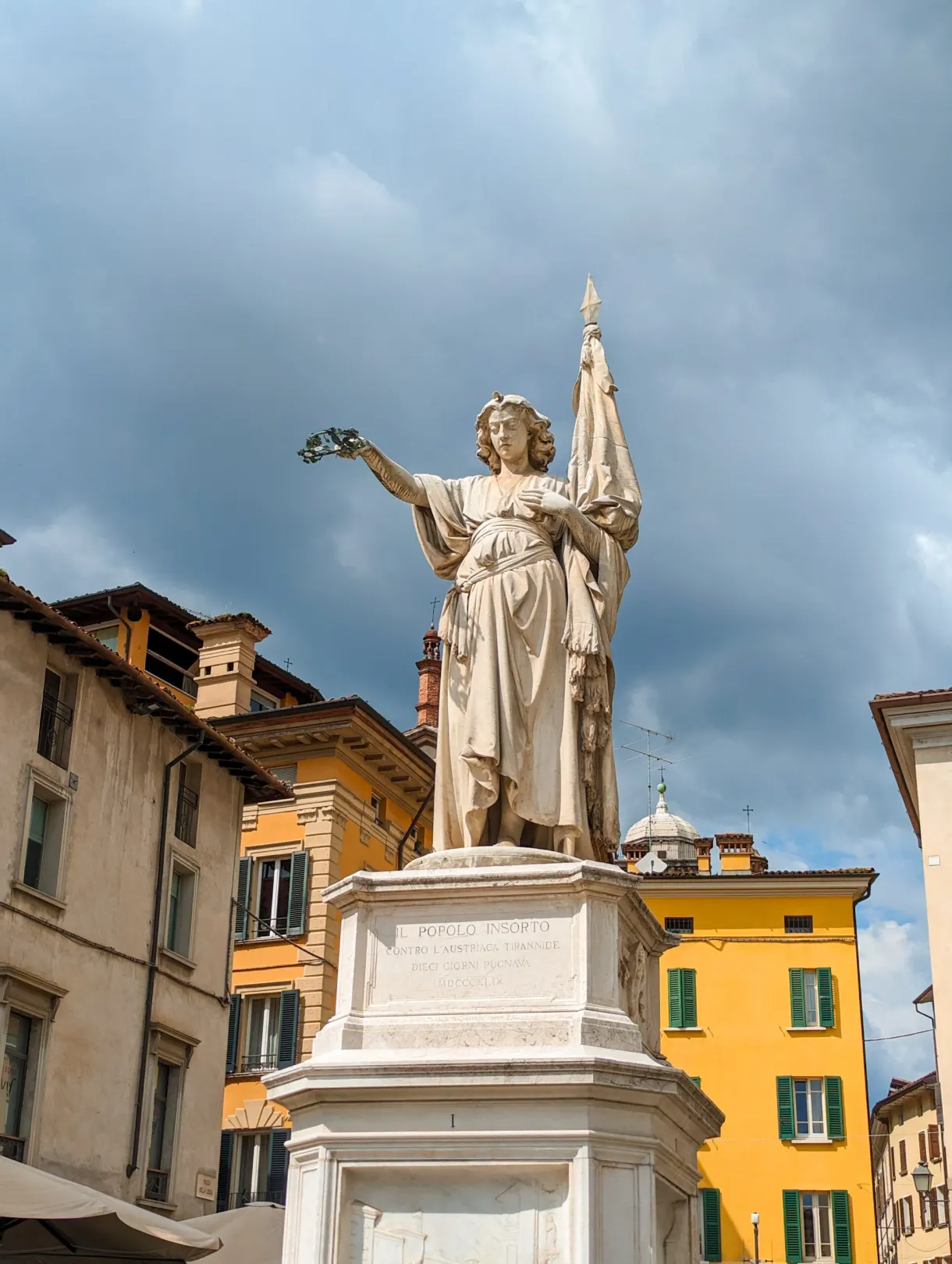 Marble statue perched on its plinth at the centre of the square