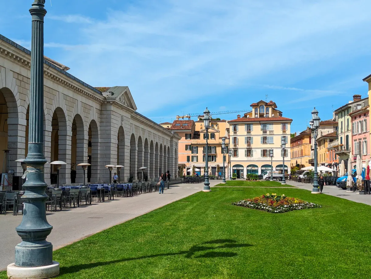 Long colonnade lining a square with flowering lawn