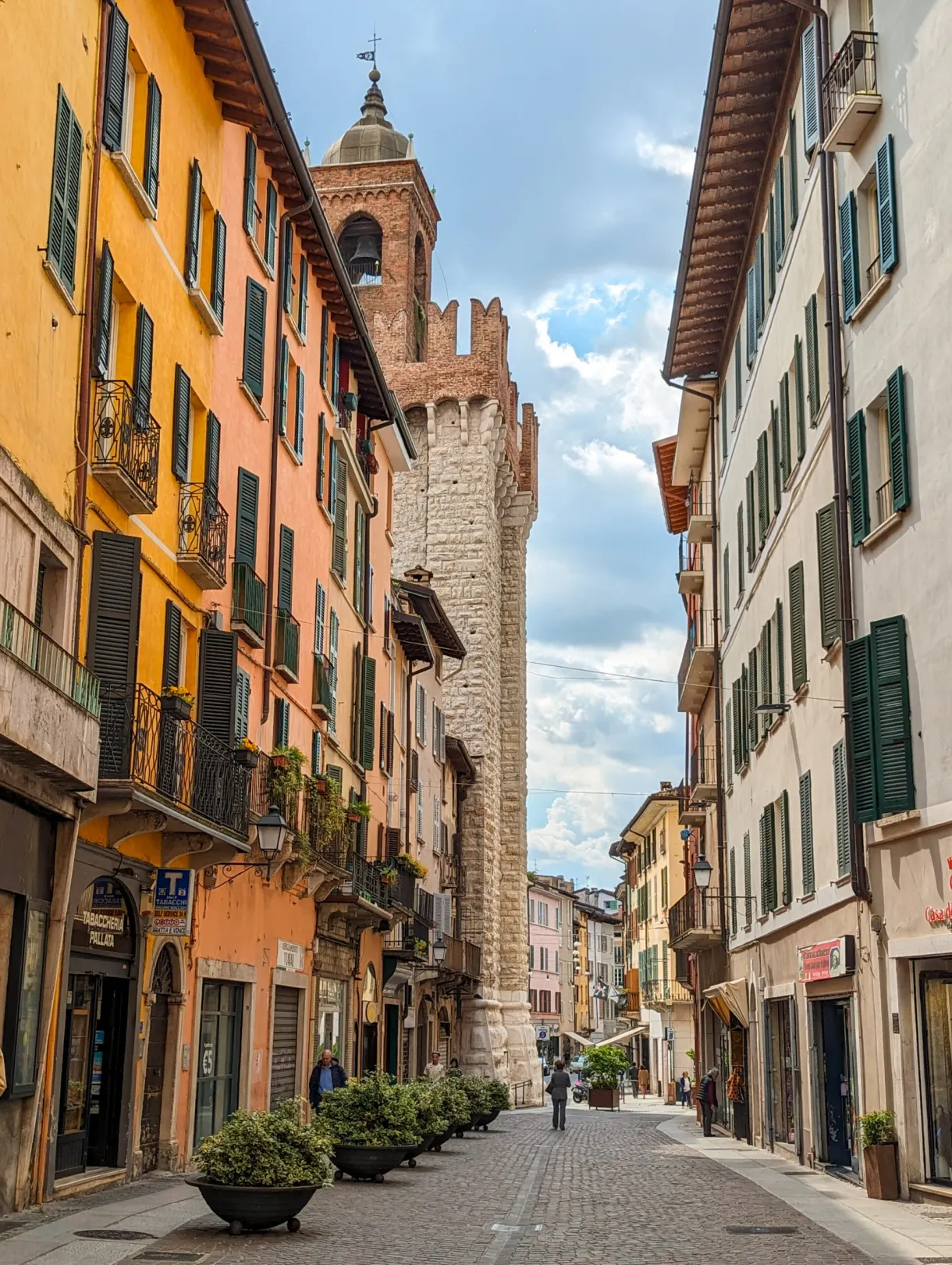 Shopping street leading to a medieval brick tower