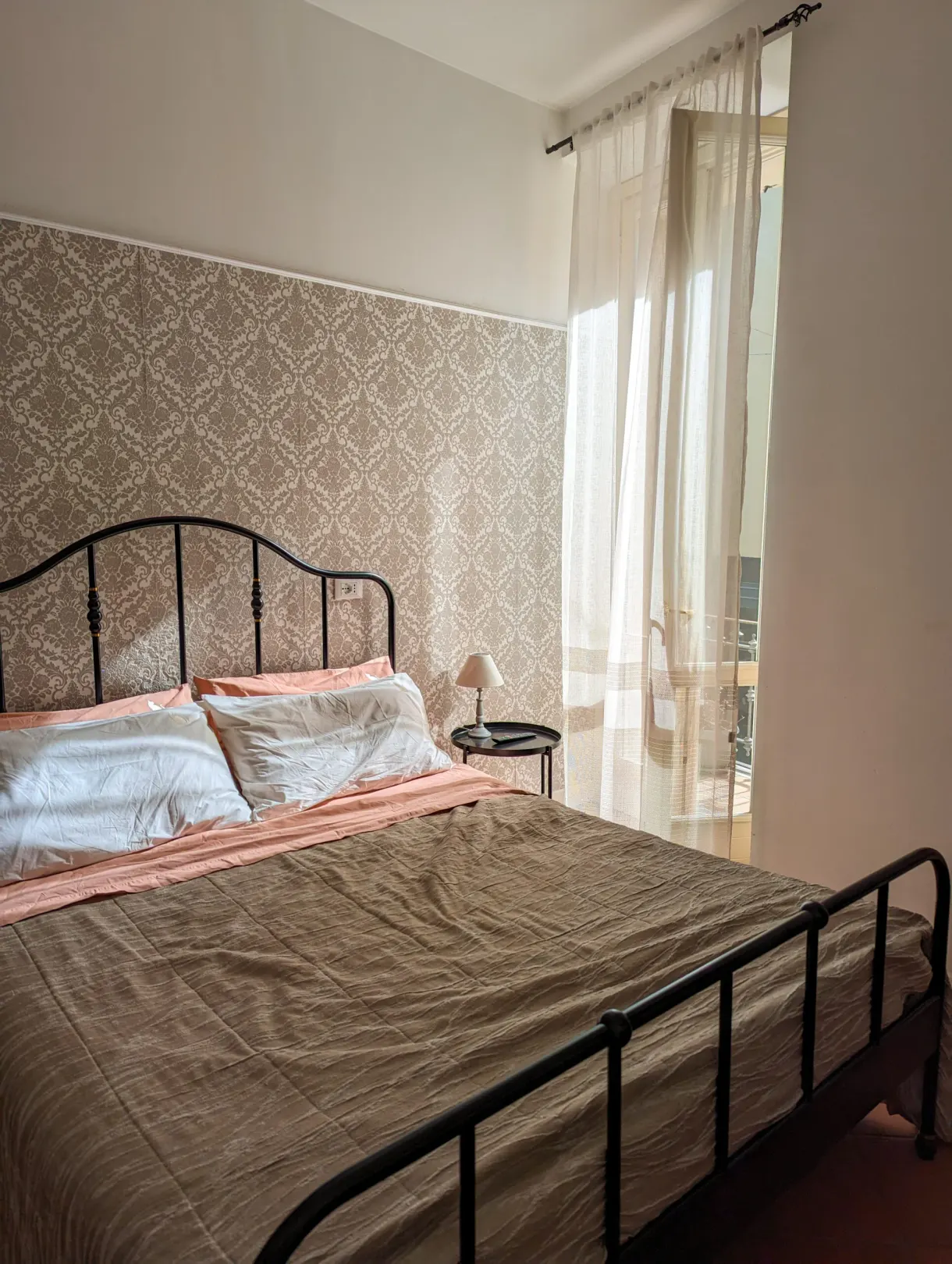 Wrought iron bed and light curtains in the rented room
